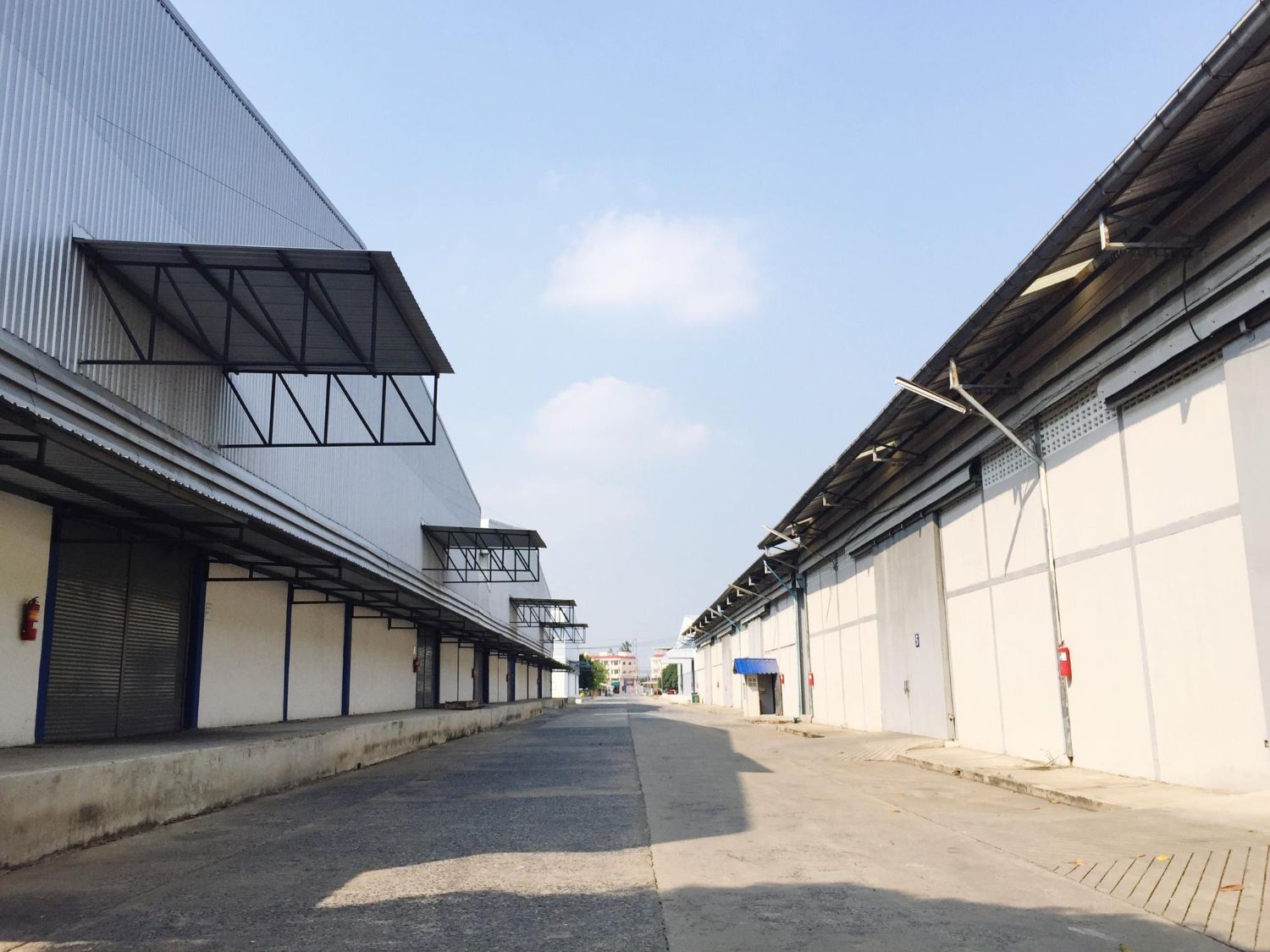 A row of warehouses are lined up next to each other on a sunny day.