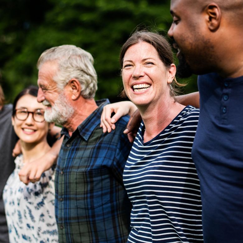 A group of people are standing next to each other and smiling.
