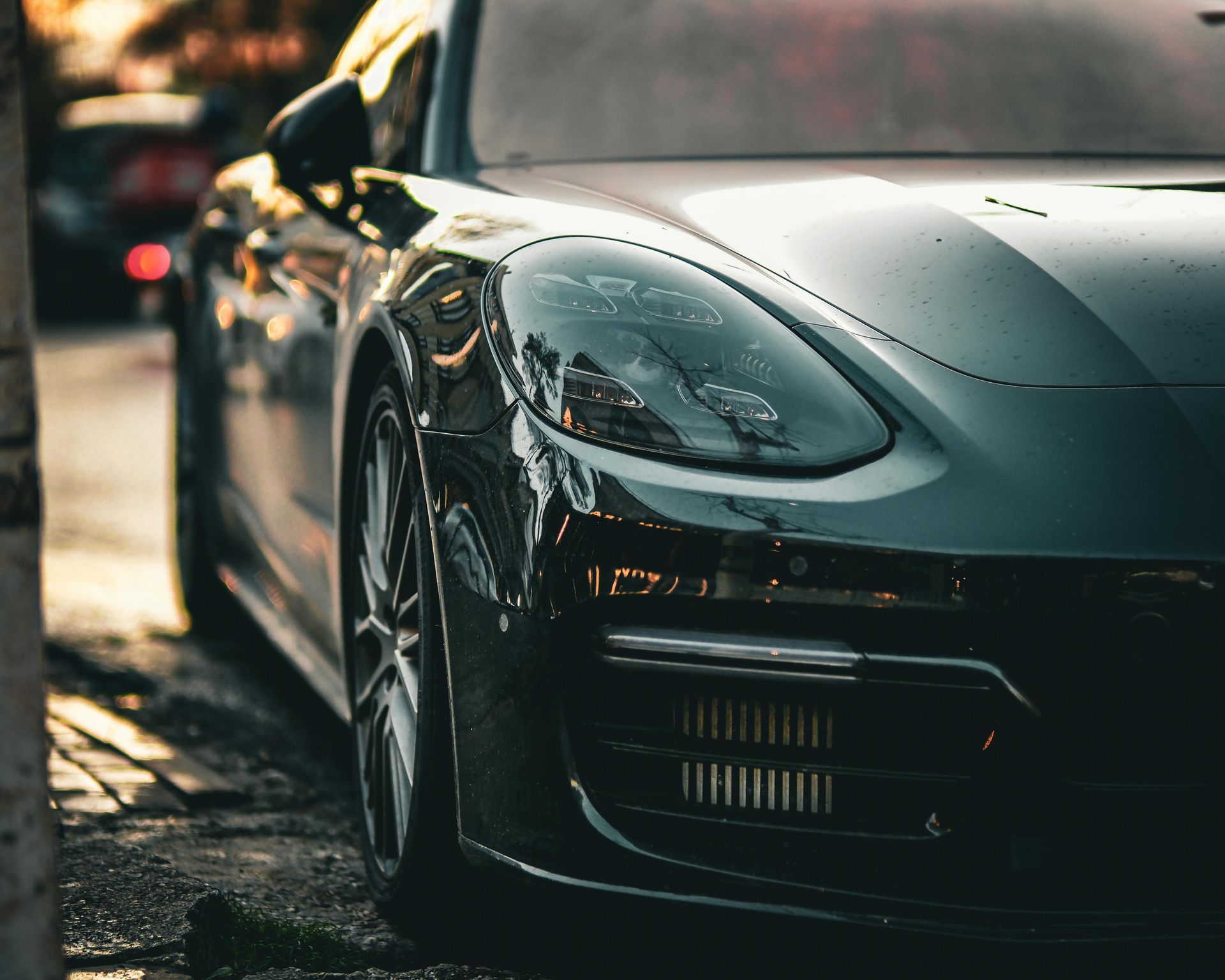 A black sports car is parked on the side of the road.