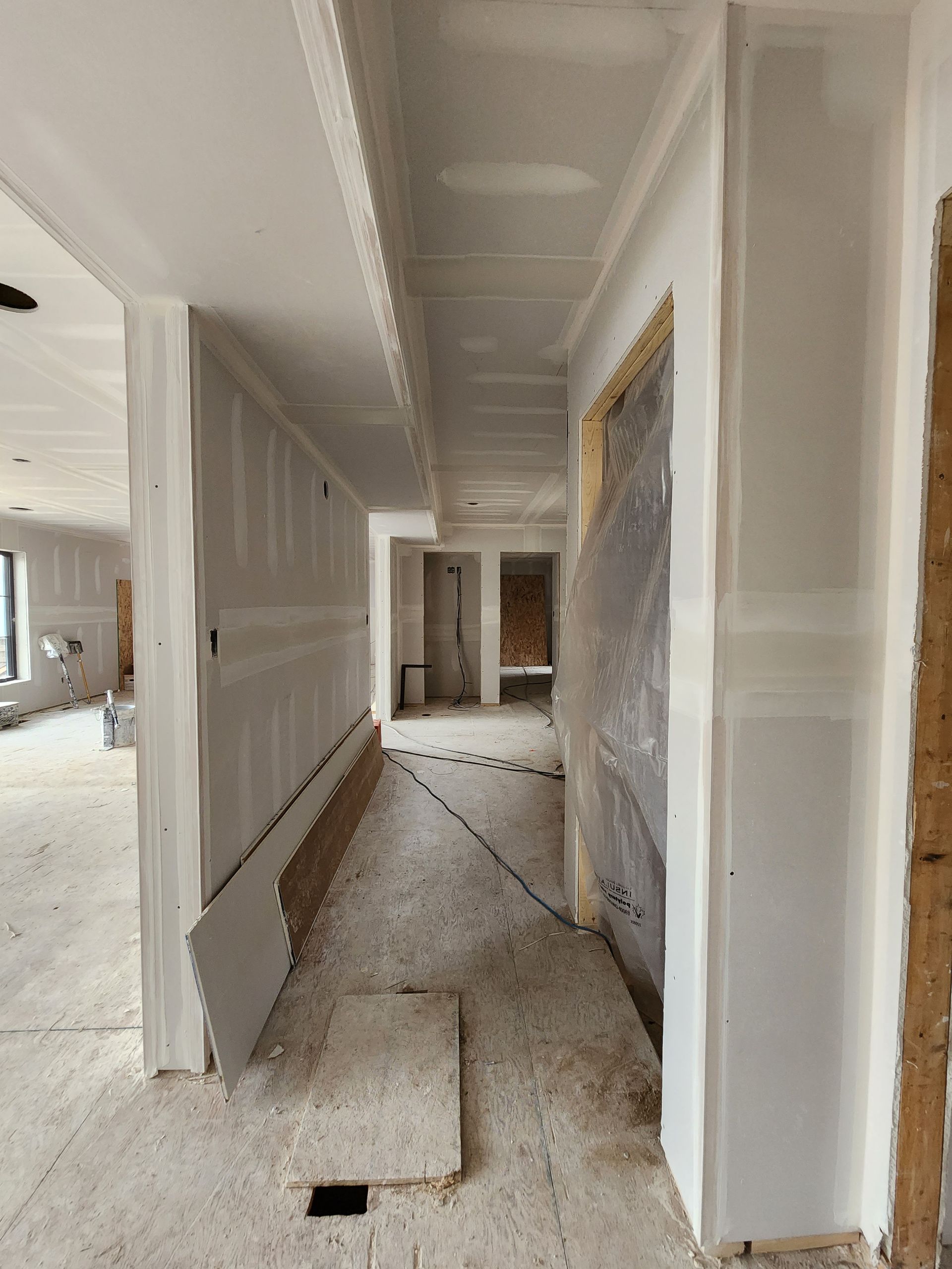 a long hallway in a house under construction .