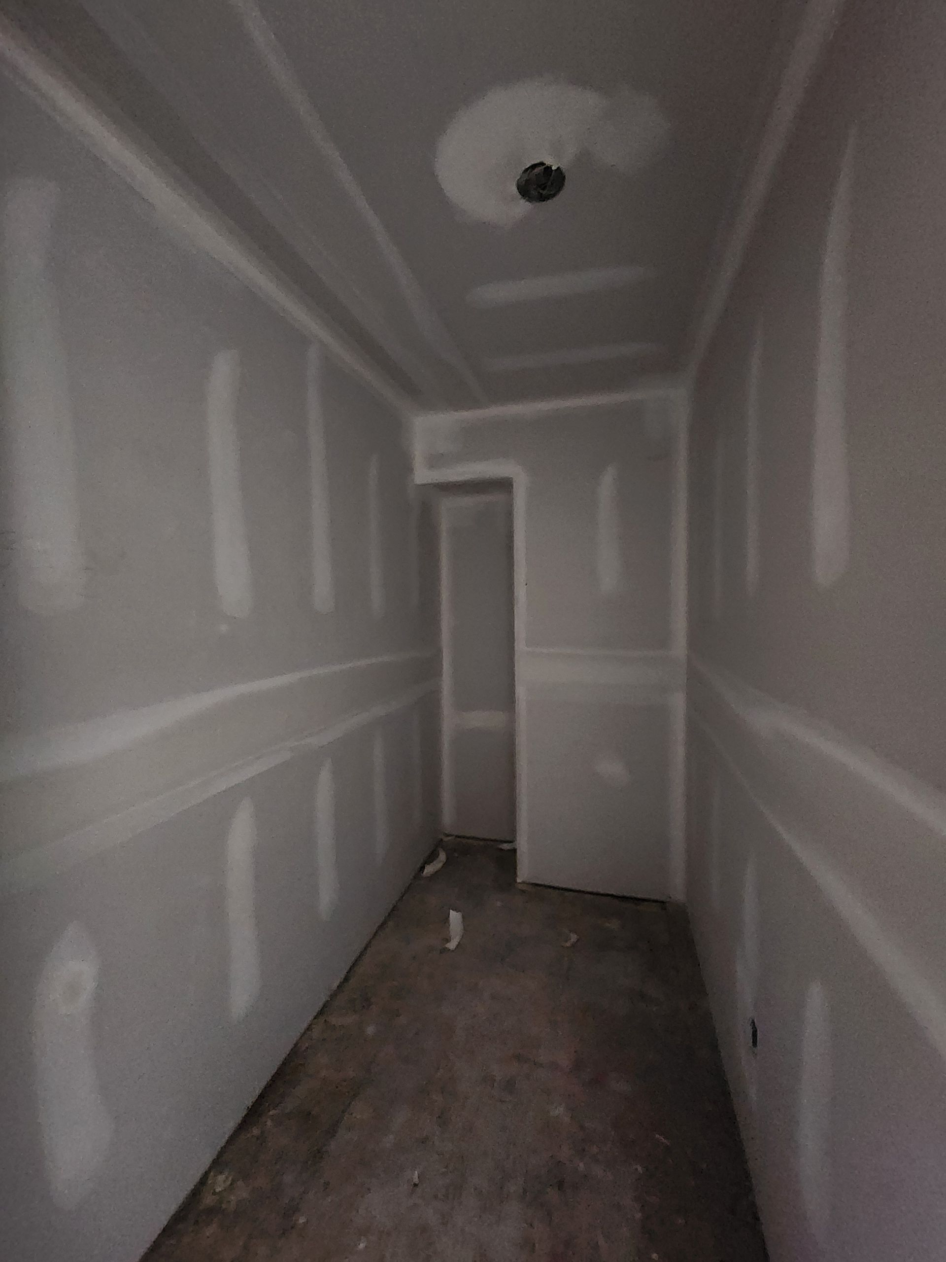 an empty room with drywall on the walls and a door .