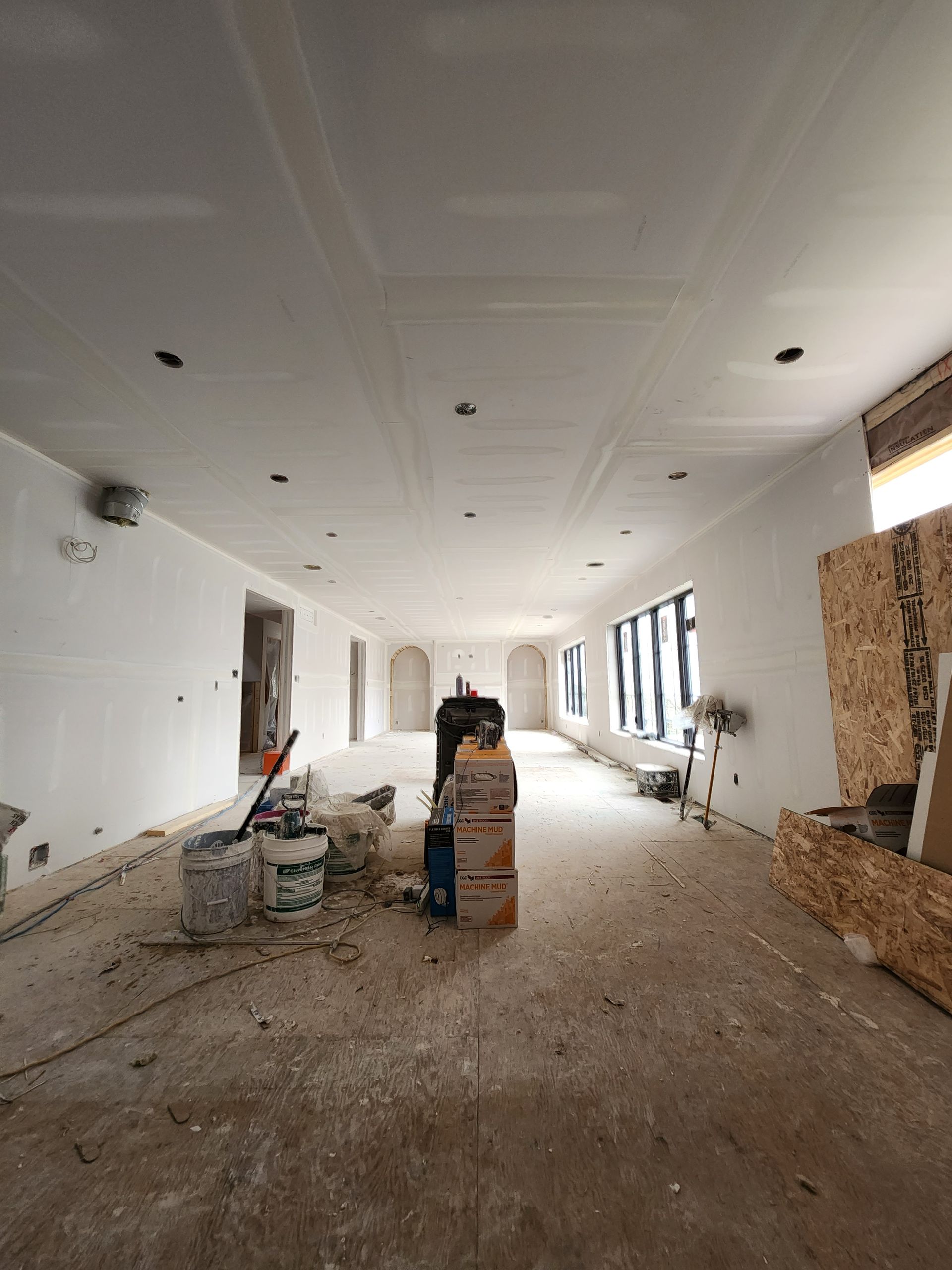 a large empty room with a man standing in the middle of it .