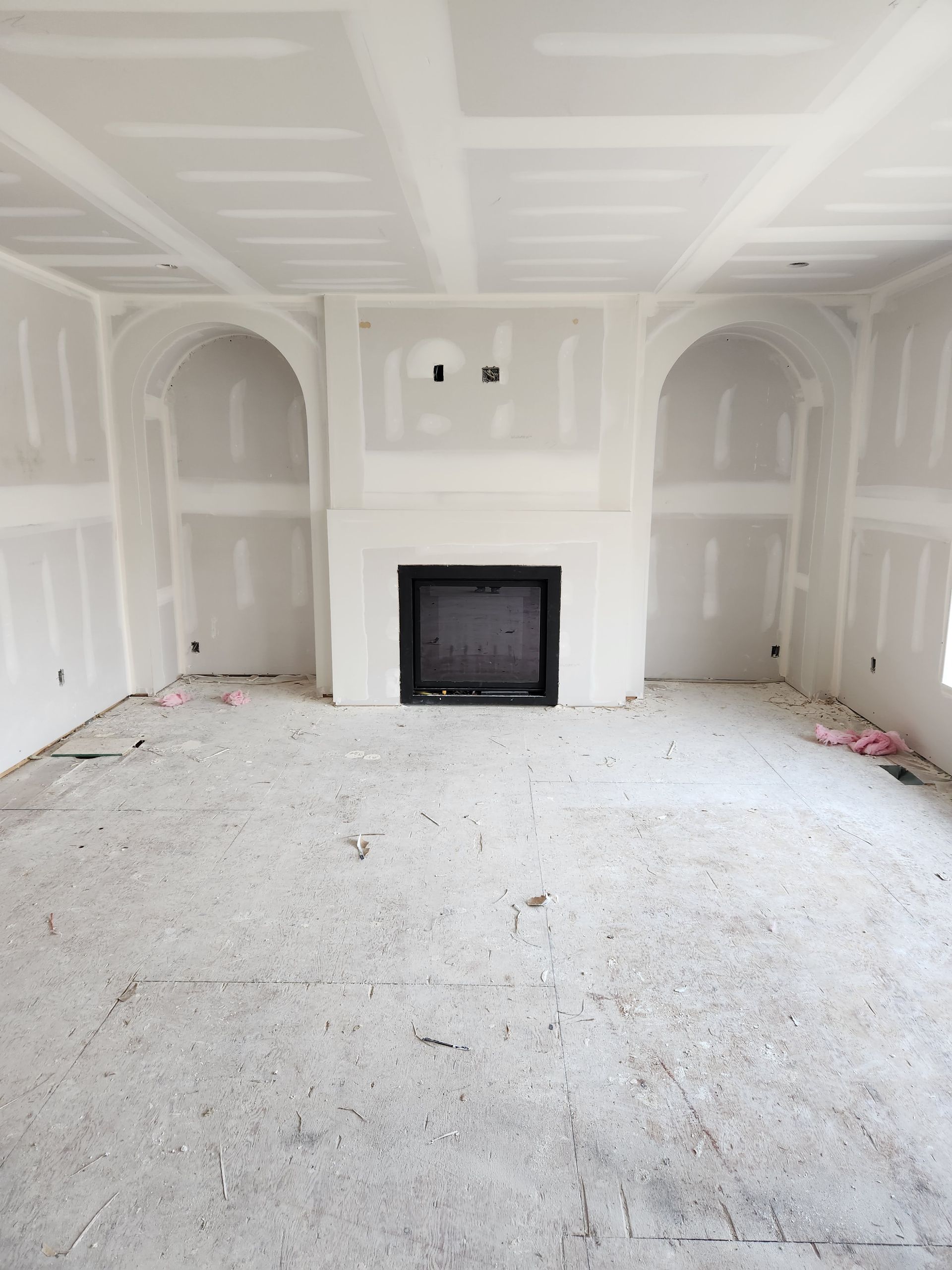 an empty room with a fireplace and a flat screen tv