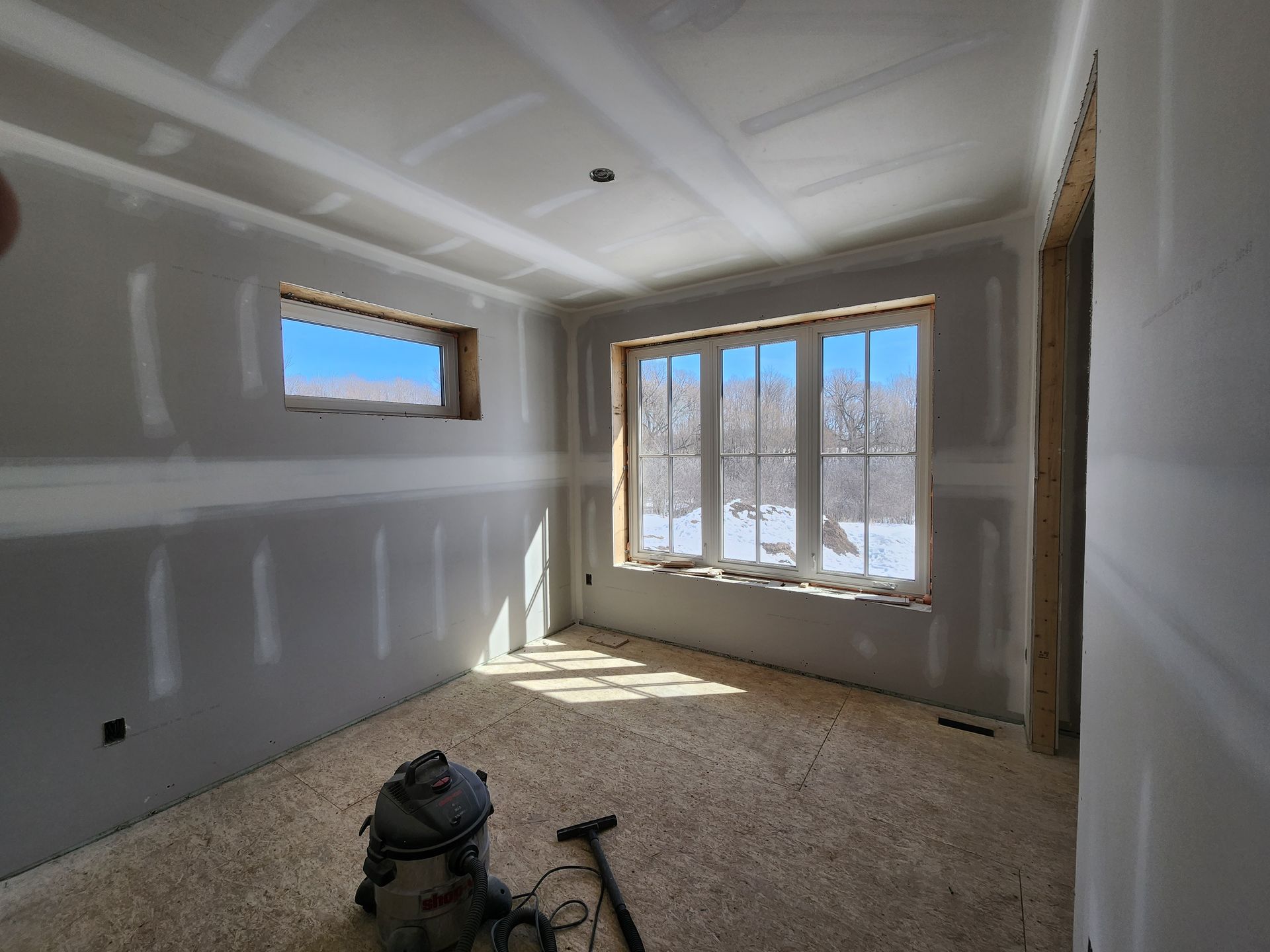 a room with a vacuum cleaner in it and a window .