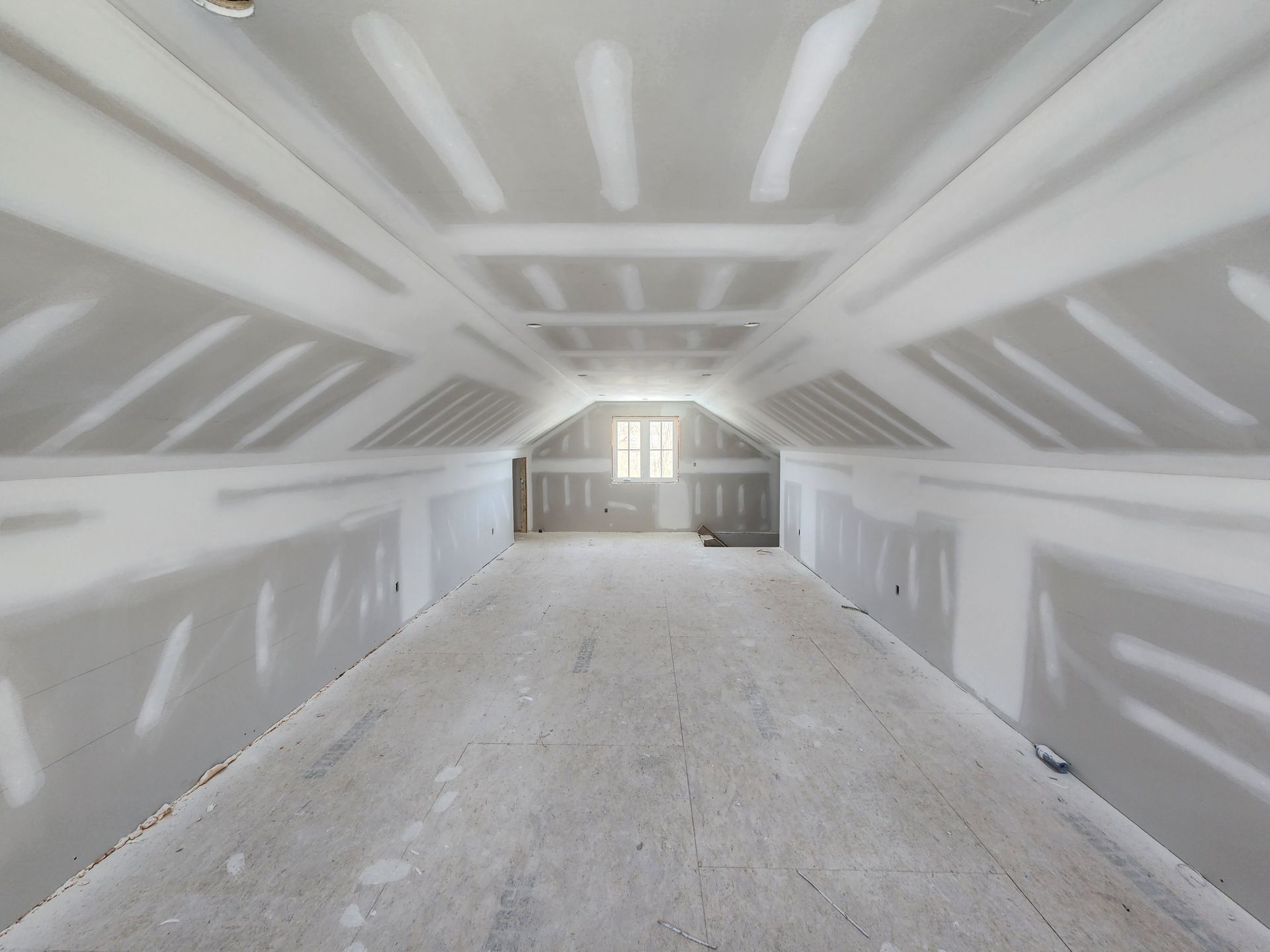 an empty attic with drywall on the walls and ceiling