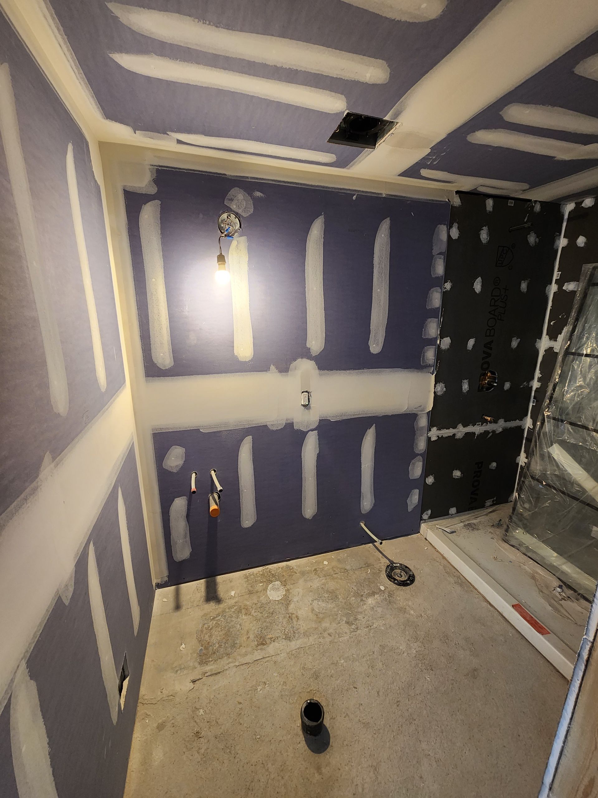 a room with a lot of drywall and a light on the ceiling