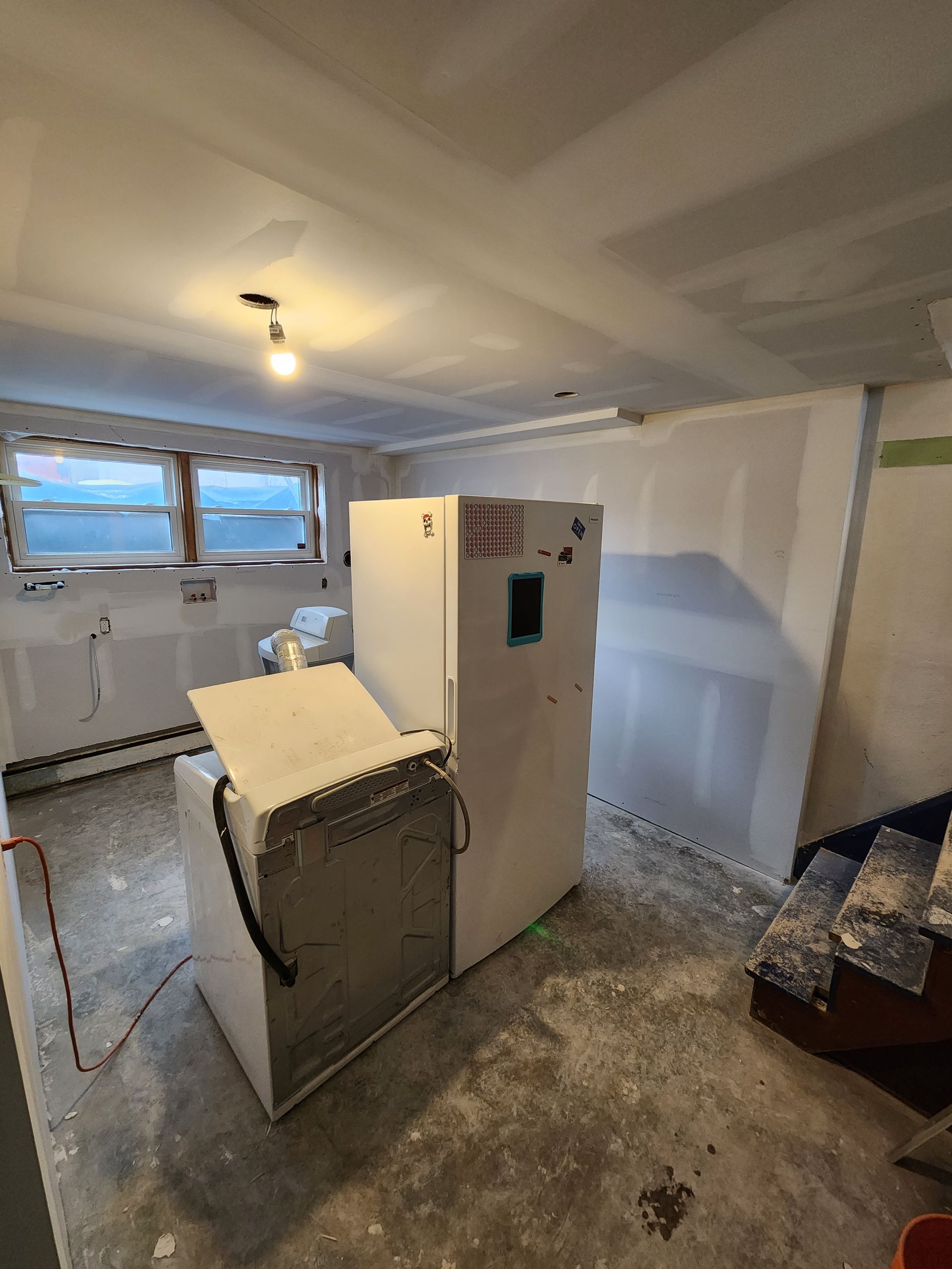 a laundry room with a washer and dryer and a refrigerator .