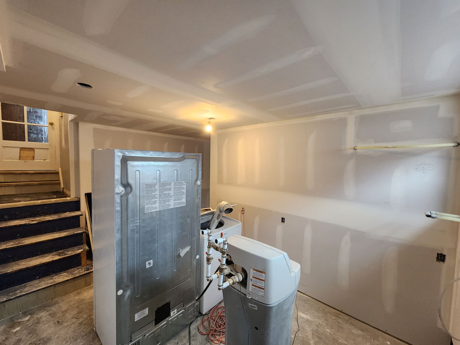 a room with a refrigerator and a washer and dryer in it .