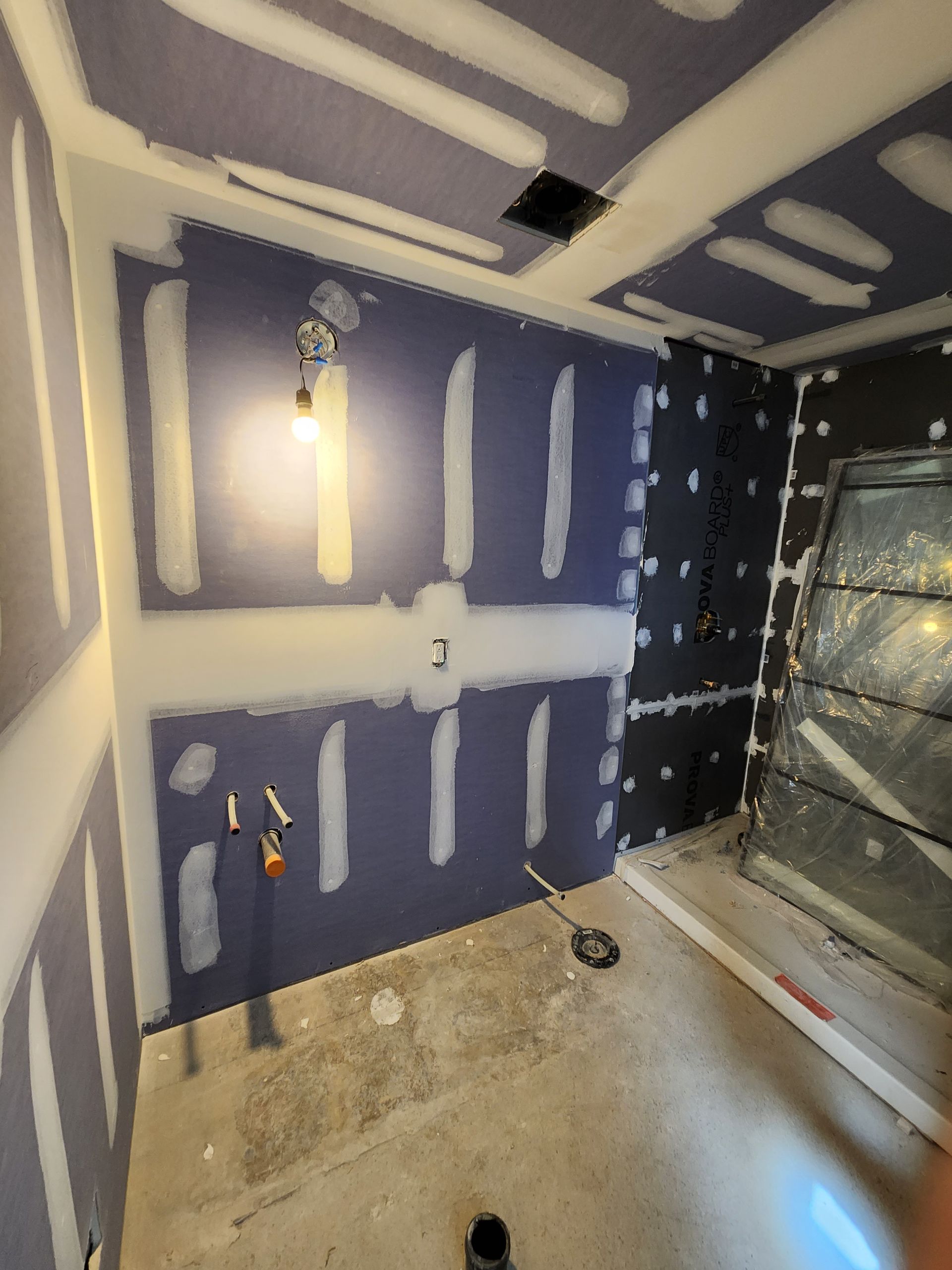 a room with a purple wall and a light on the ceiling .