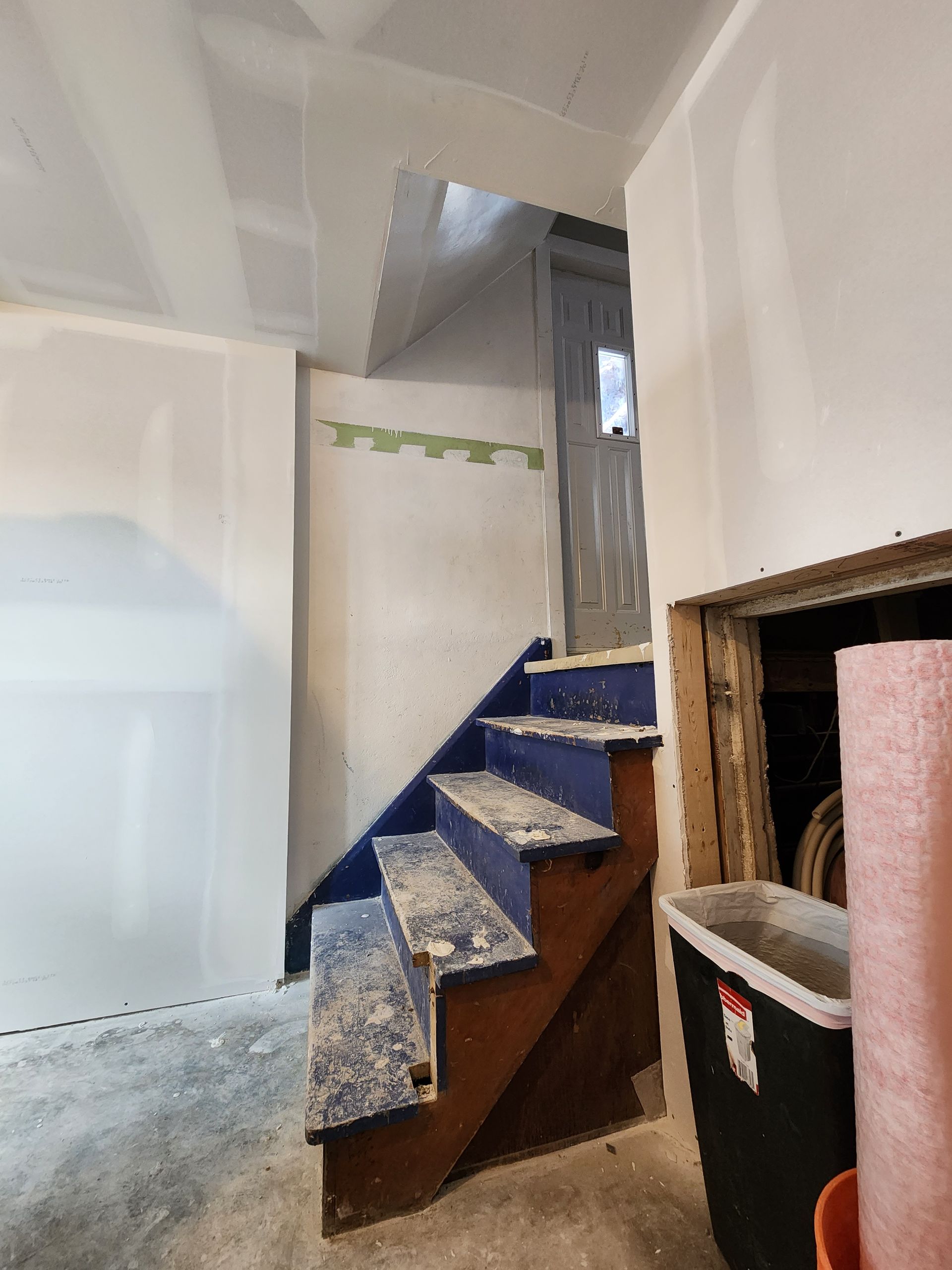 a room with stairs and a cooler in it