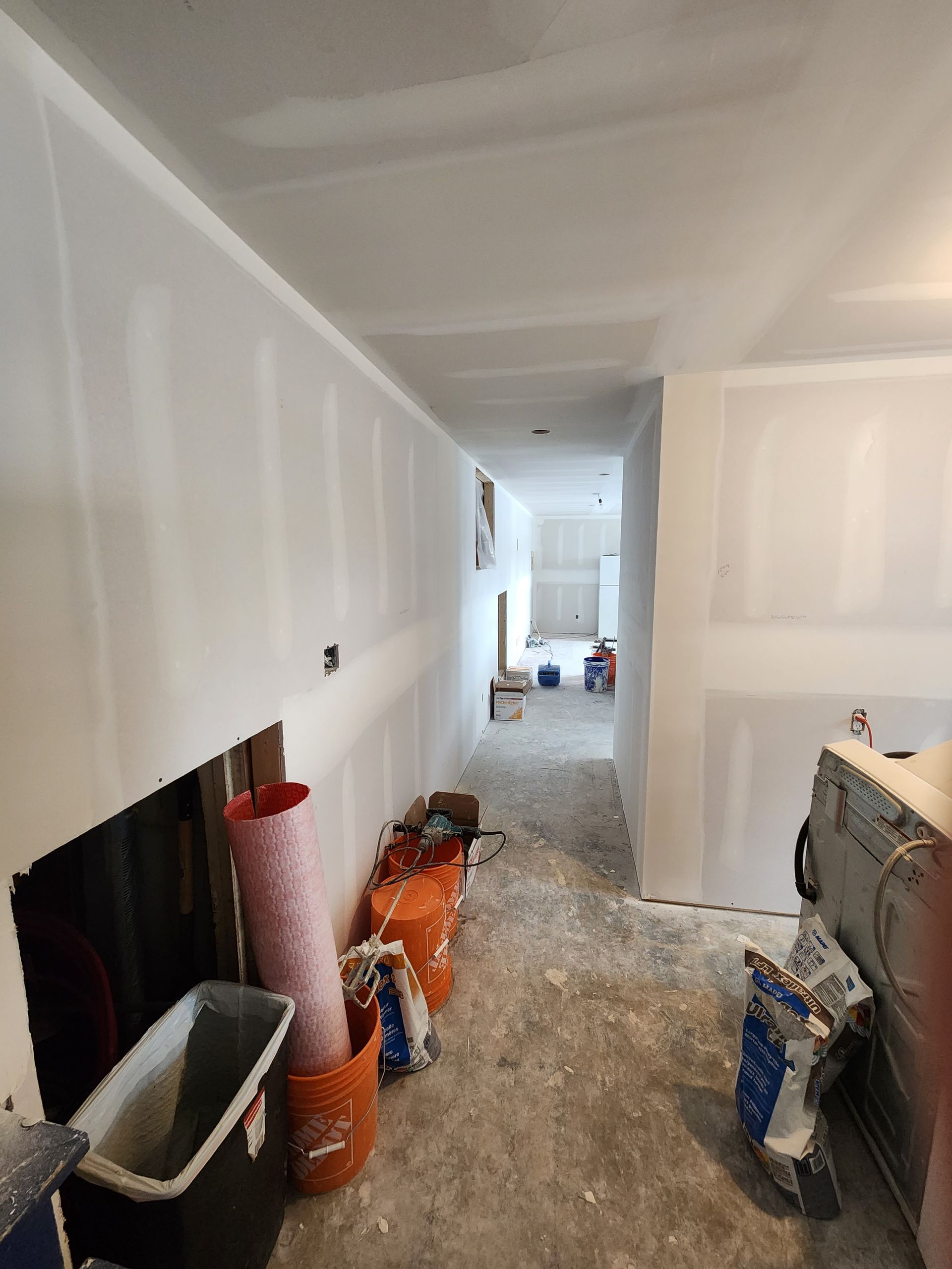 a hallway with a lot of buckets and bags on the floor