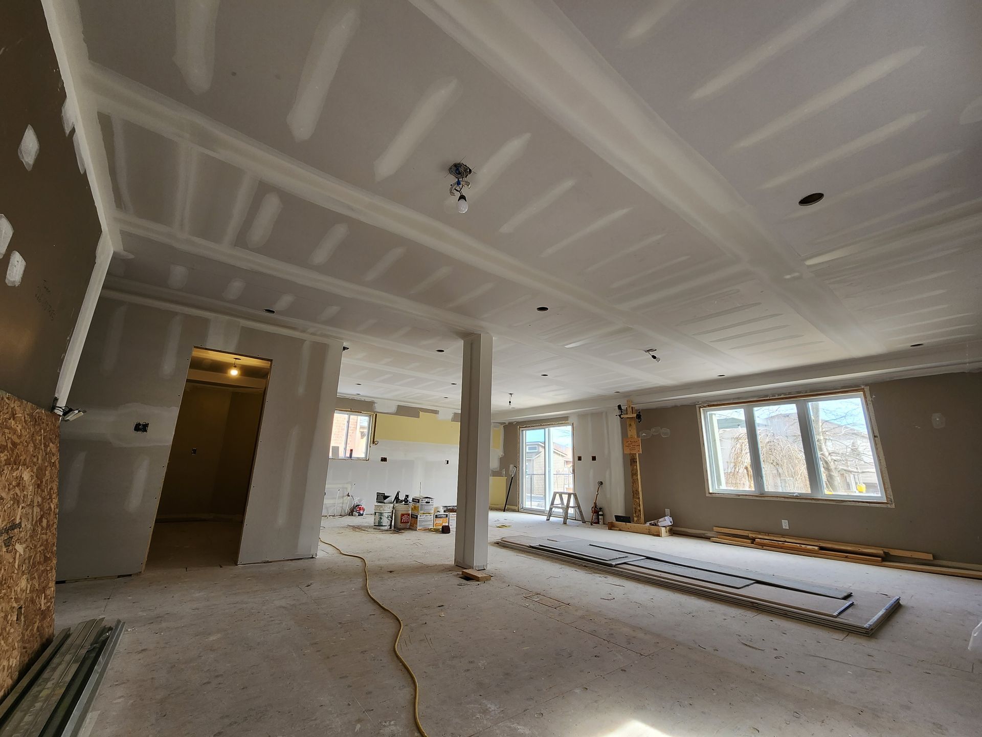 a large room with a lot of windows and drywall on the ceiling .