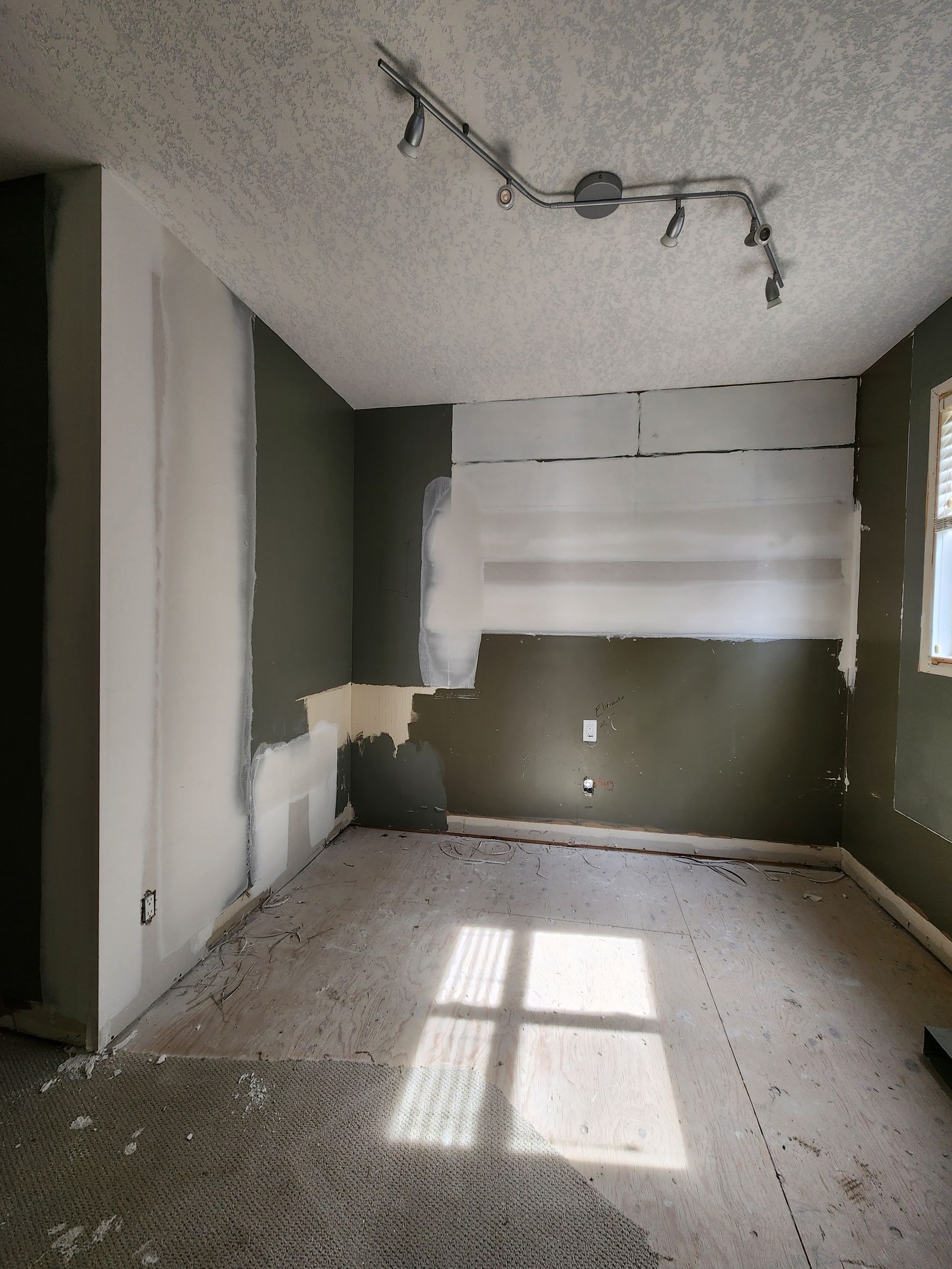 an empty room with a window and a ceiling light .