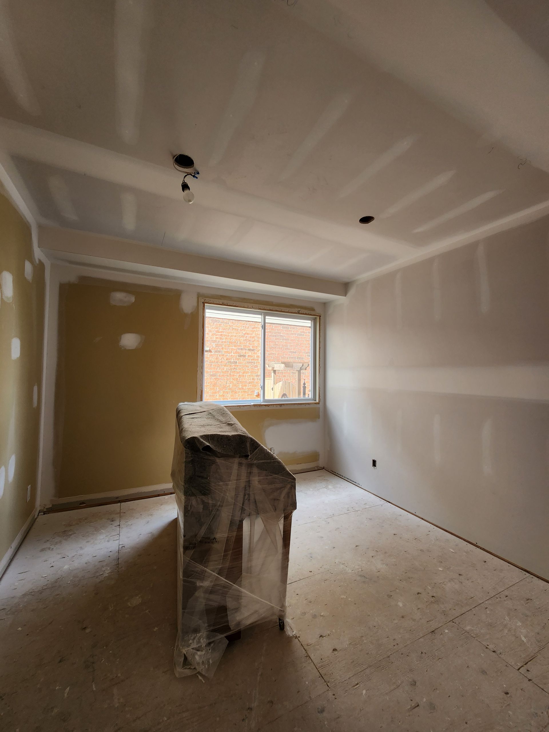 an empty room with a brick wall and a window