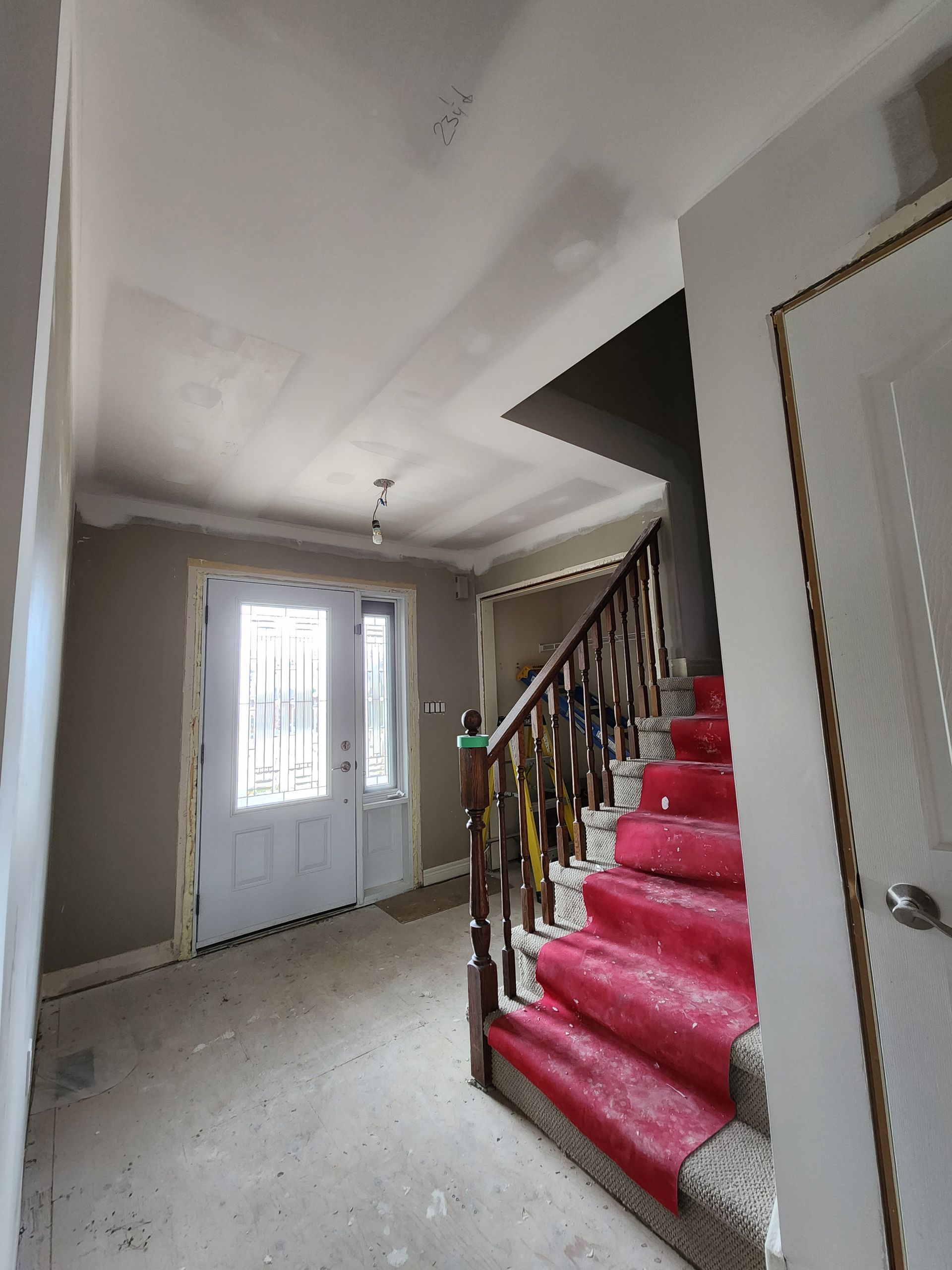 a hallway with red stairs and a white door