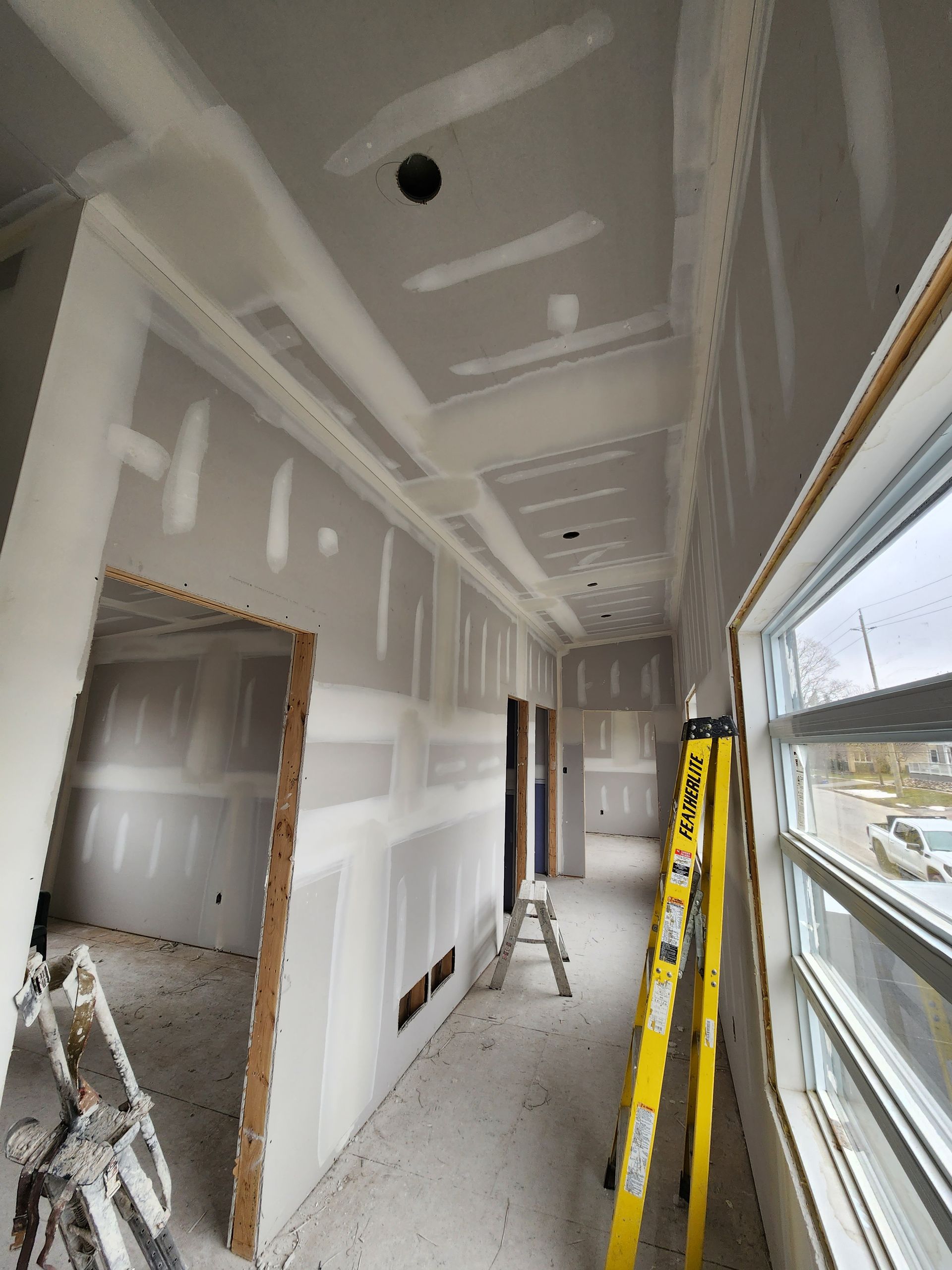 a long hallway with a yellow ladder in the middle of it .