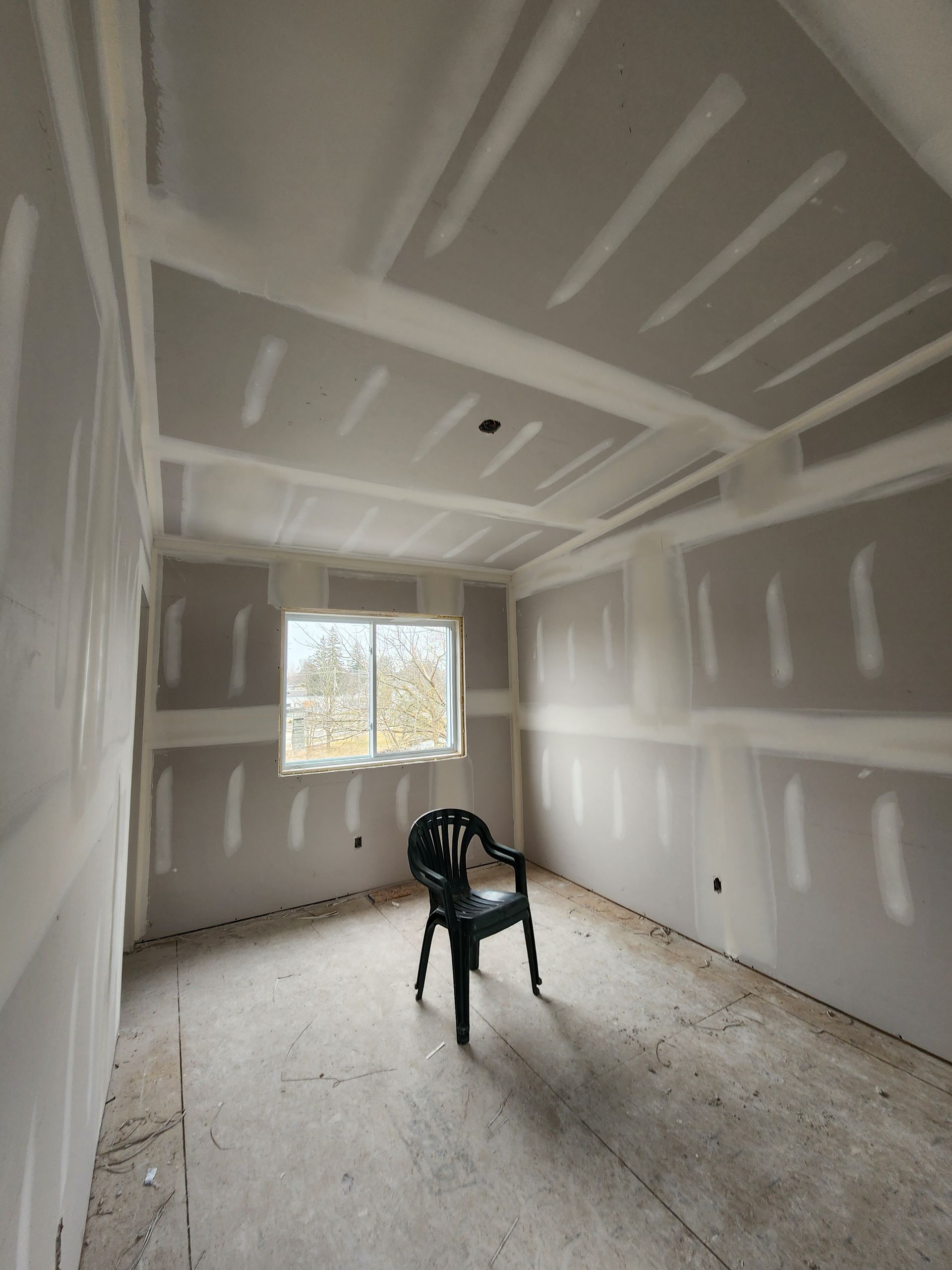 an empty room with a chair and a window