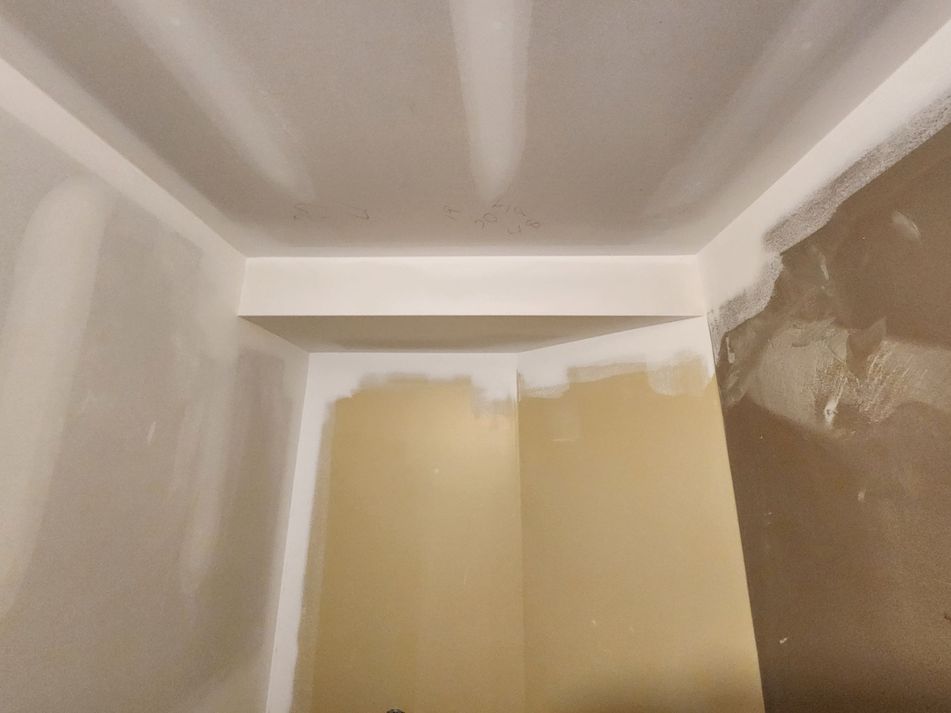 a corner of a room with a ceiling that is being painted .