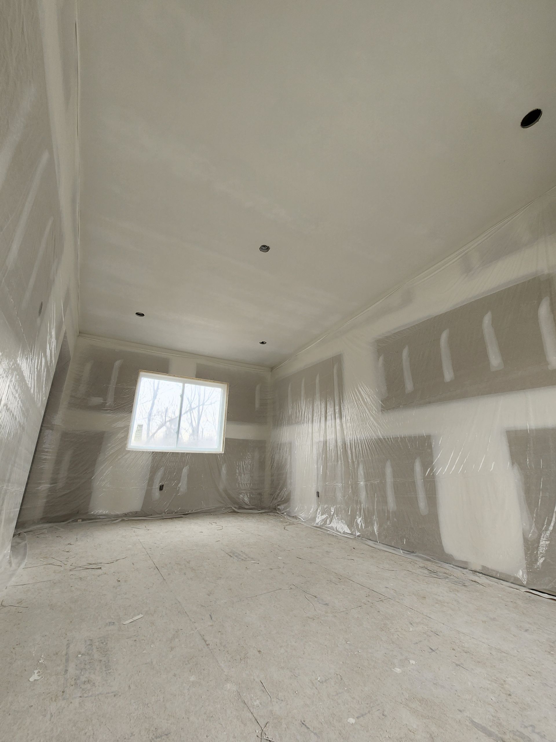 an empty room with drywall on the walls and a window .