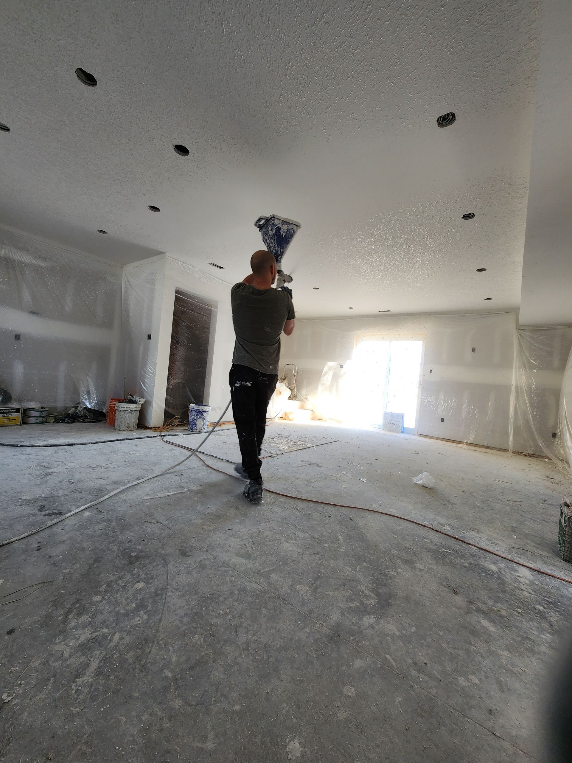 a man is standing in a room with a bucket in his hand .