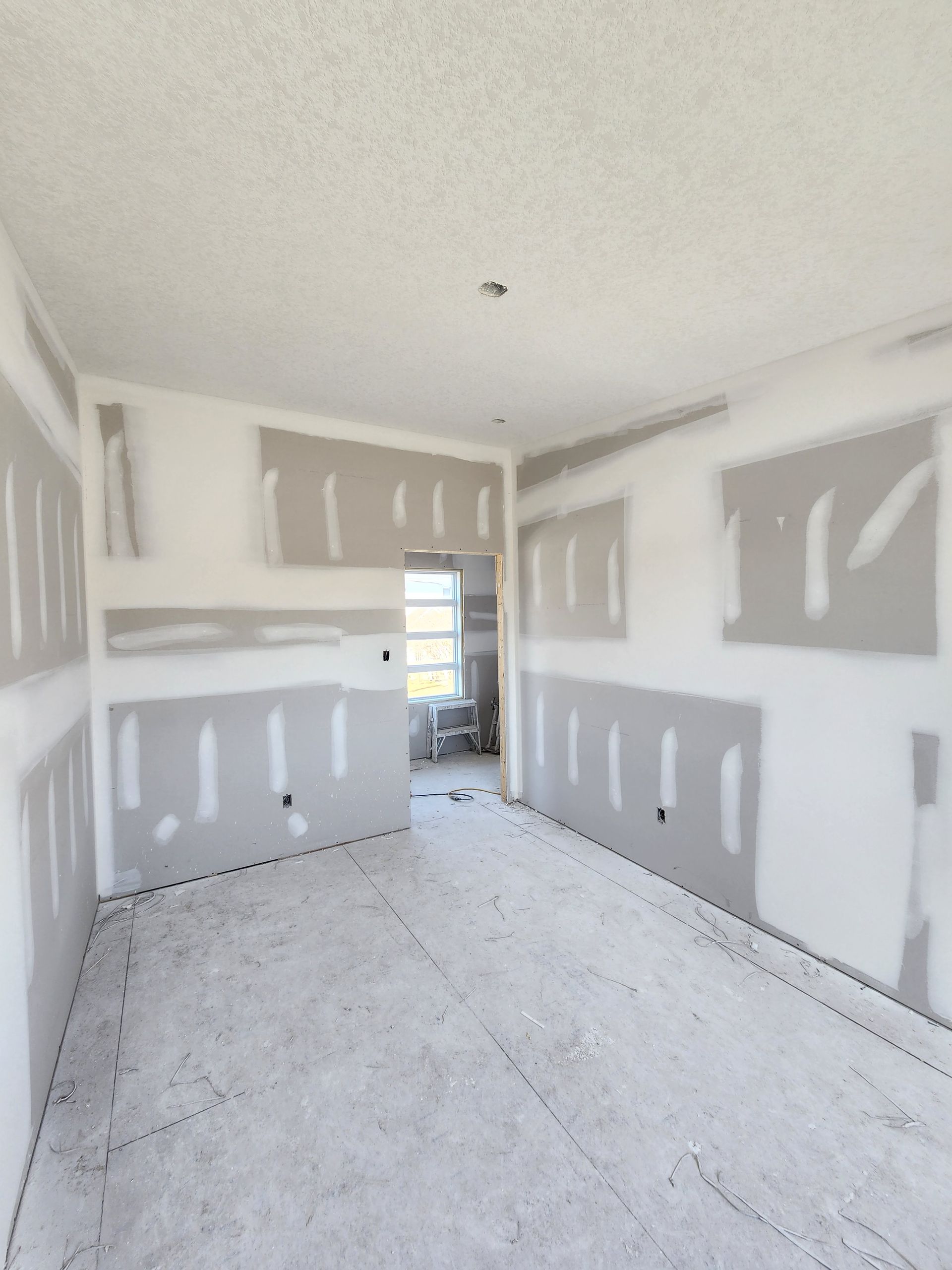 an empty room with drywall on the walls and floor