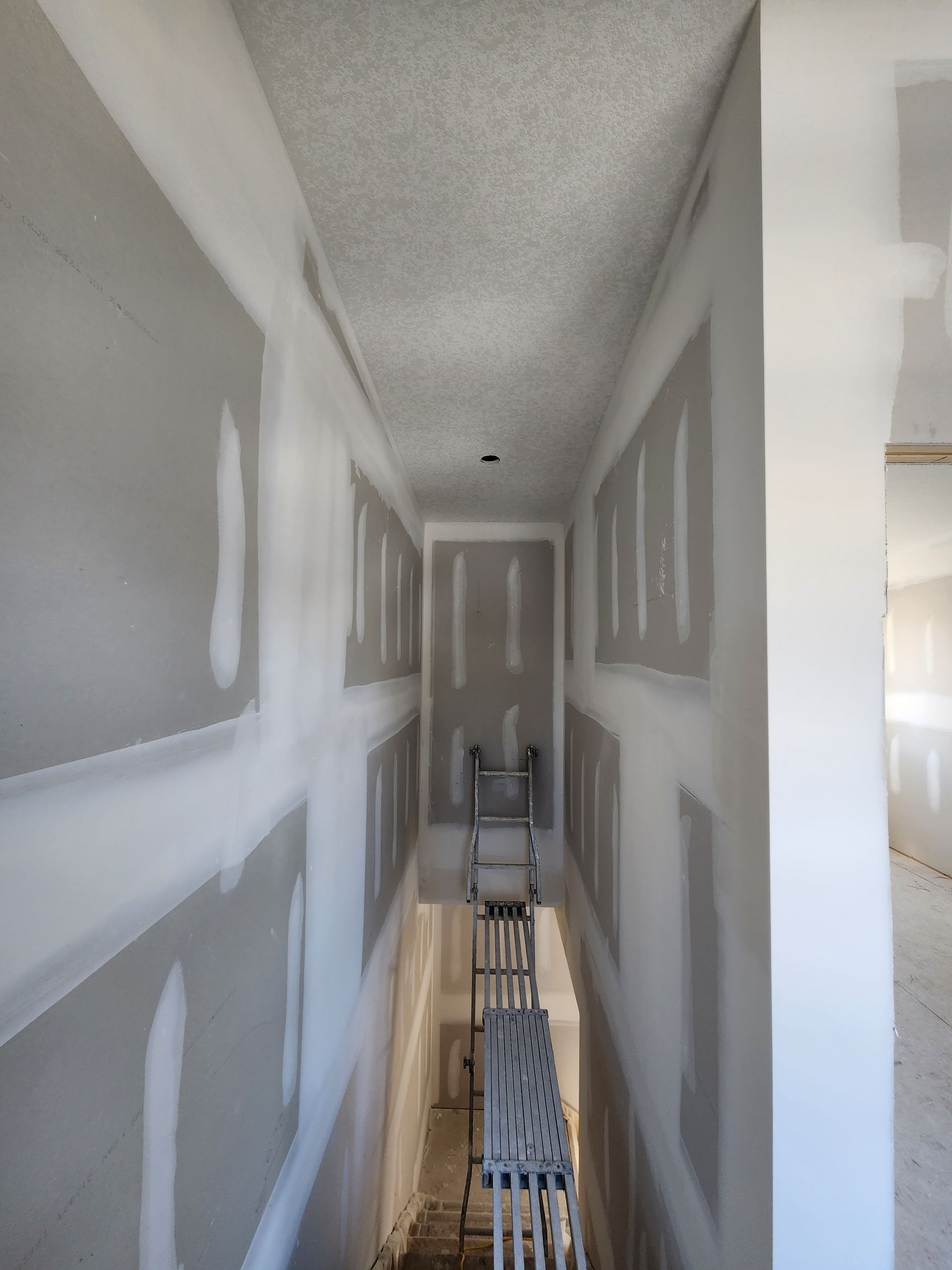 a long hallway with a ladder in the corner