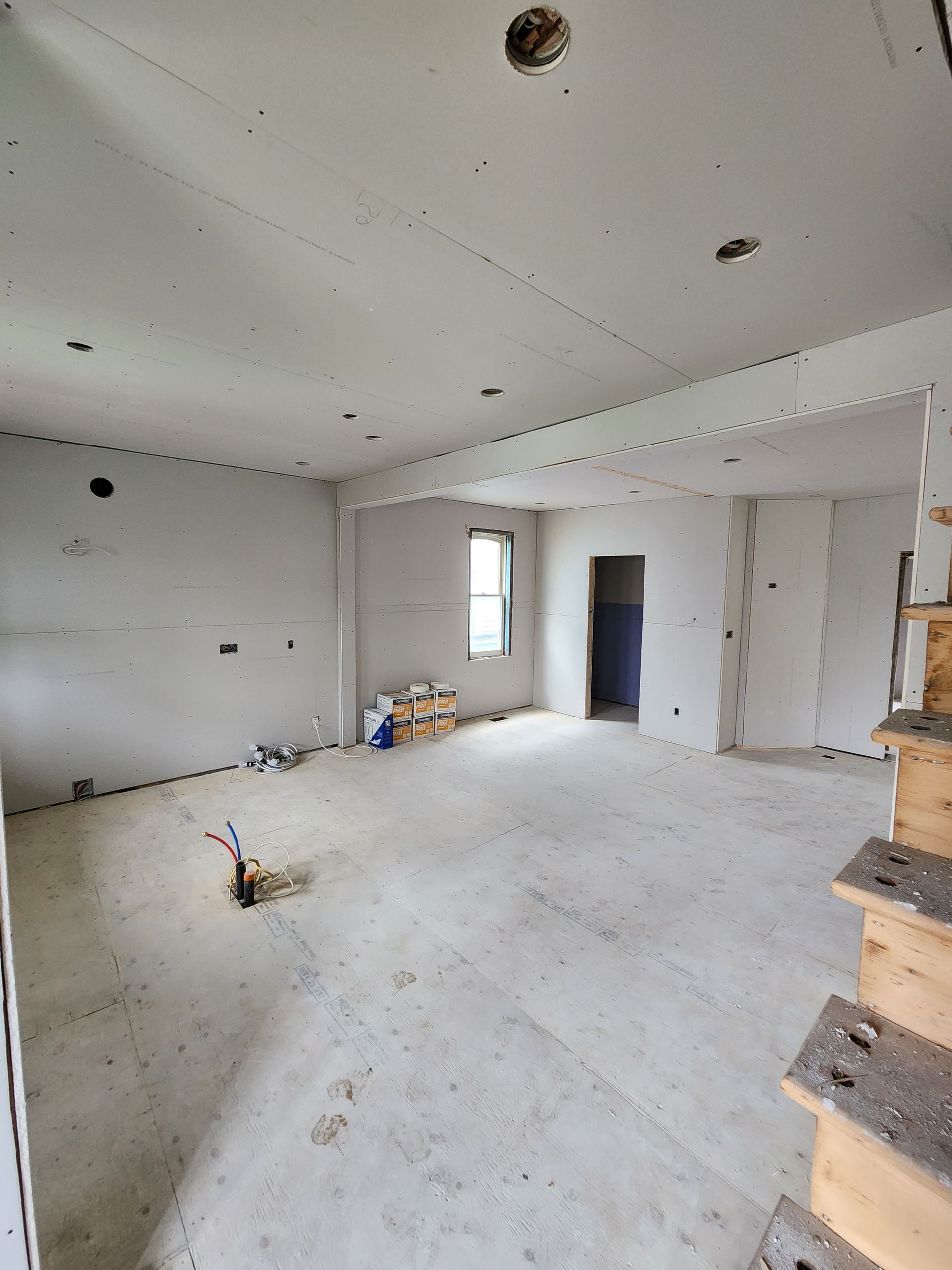 a large empty room with stairs and a window .