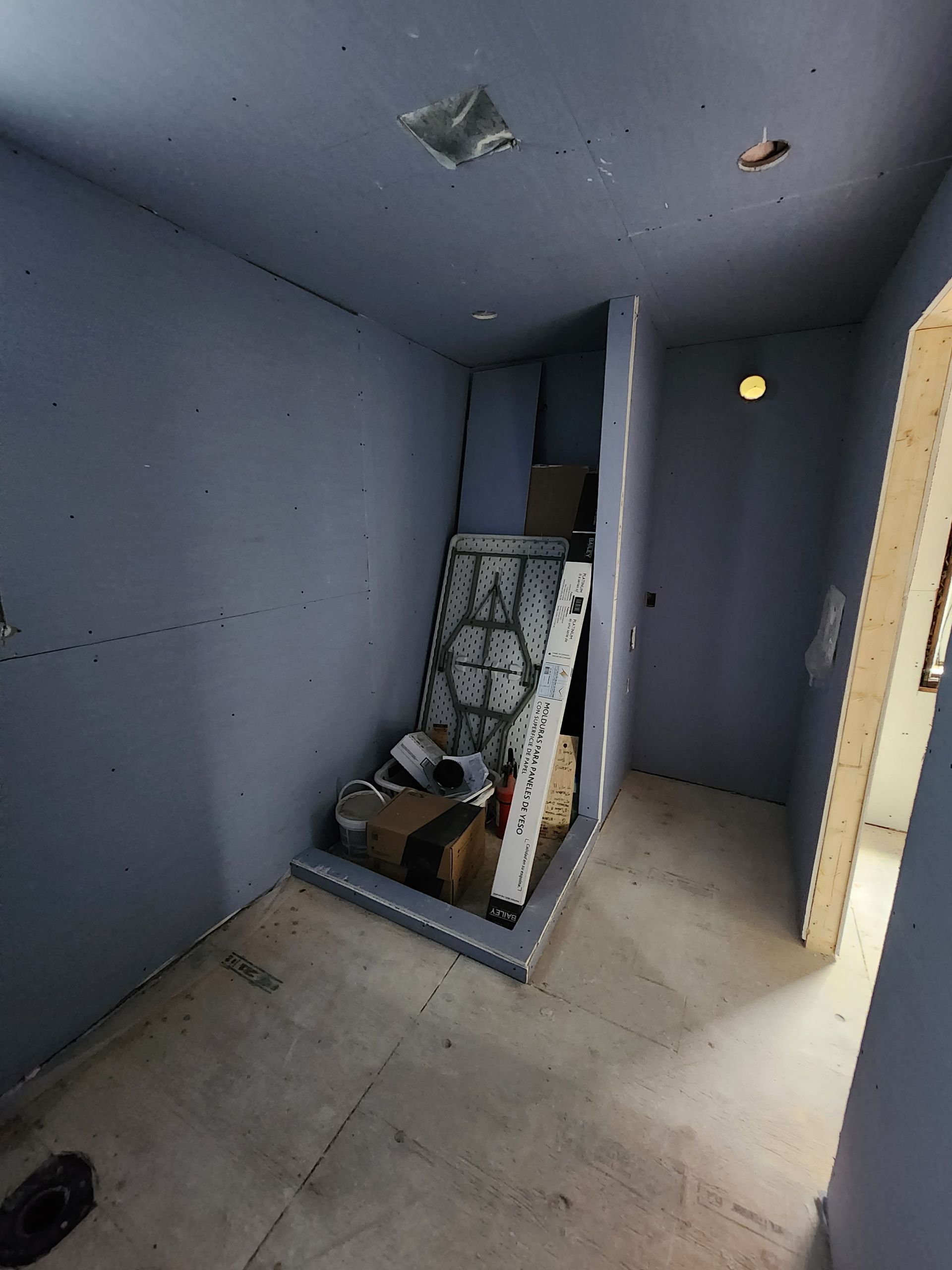 a room with a lot of boxes on the floor and a door .