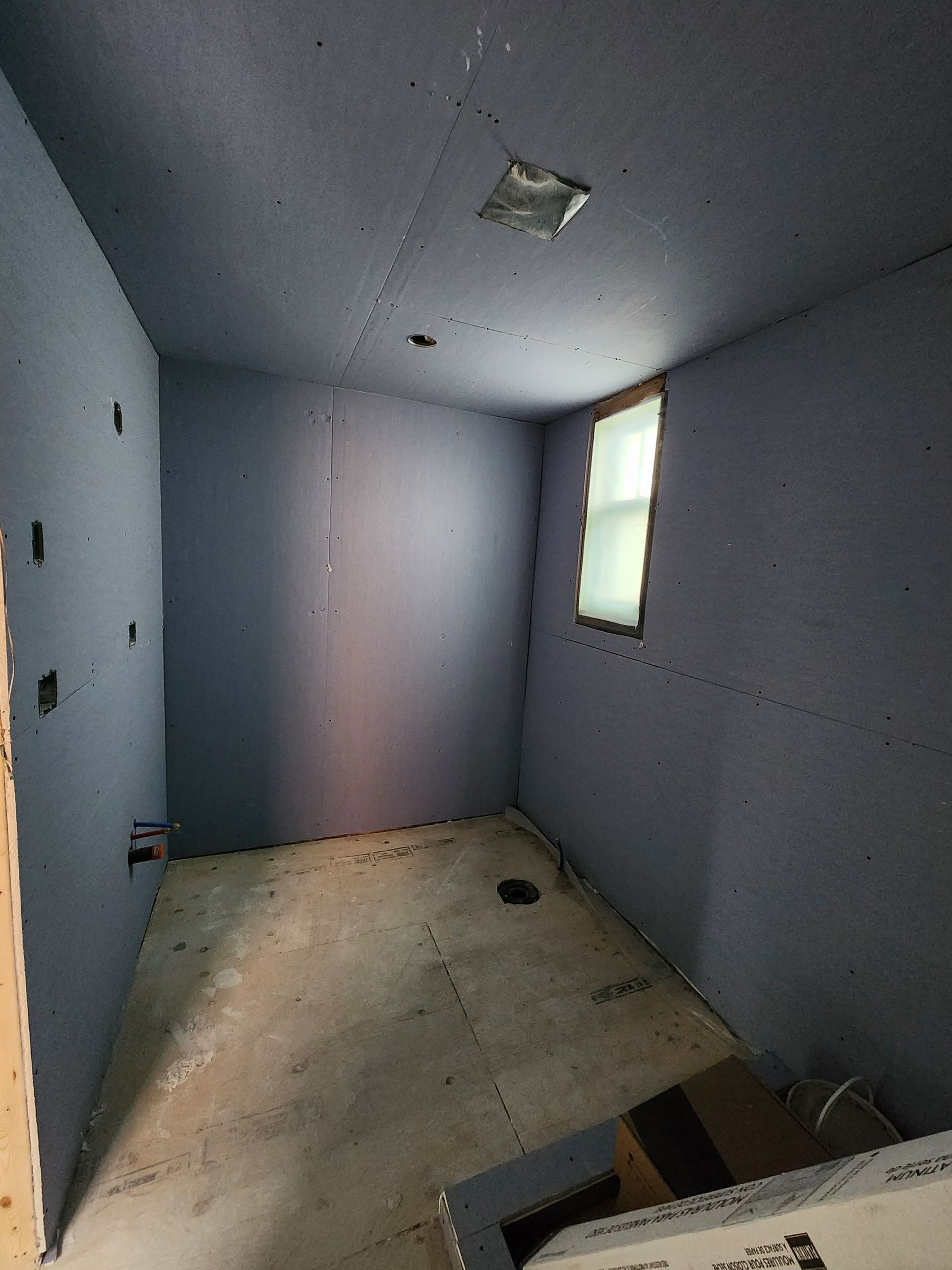 a room with a window and a ceiling that is being remodeled .