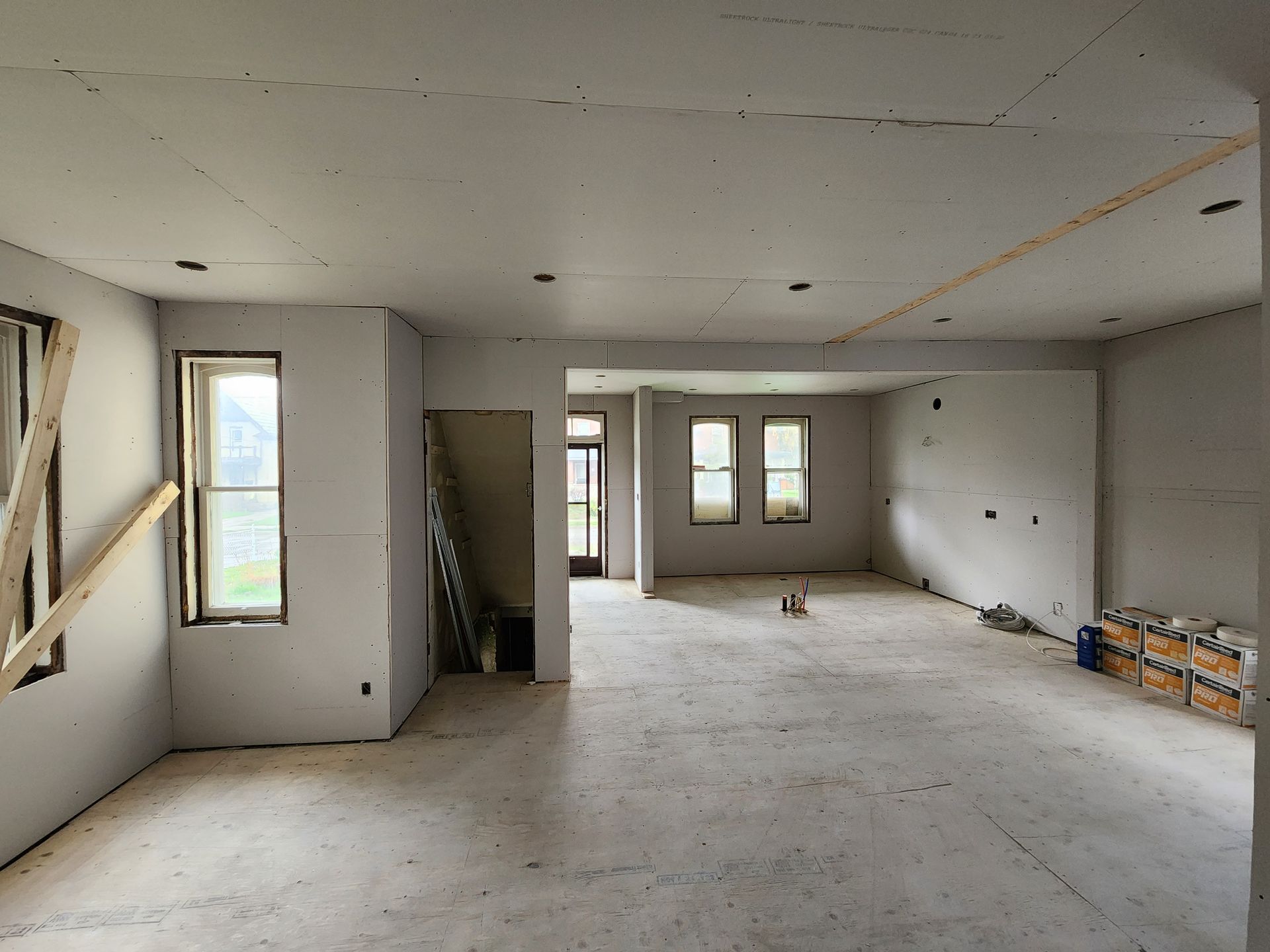 an empty room with a lot of windows and drywall
