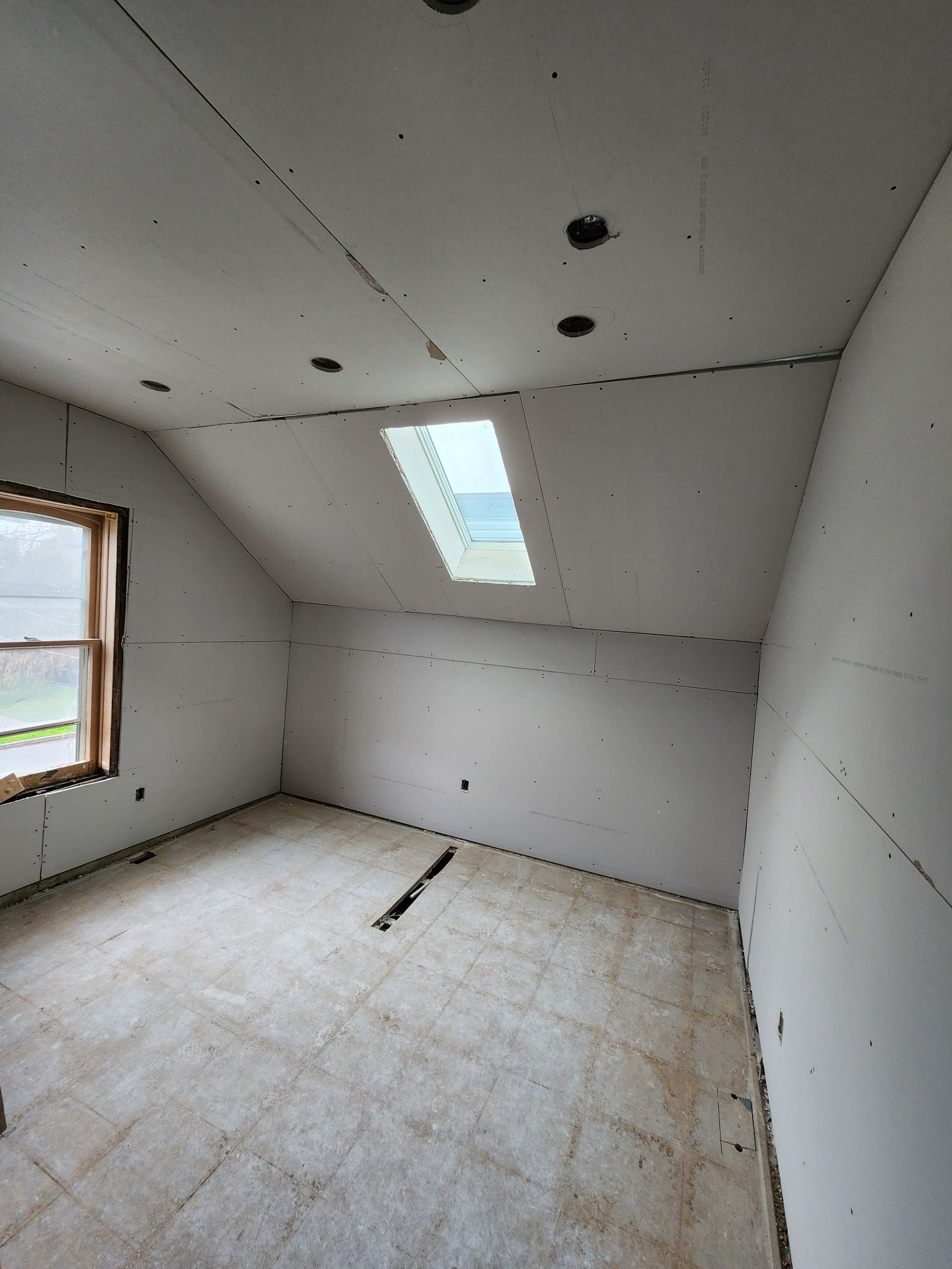 an empty room with a skylight in the ceiling