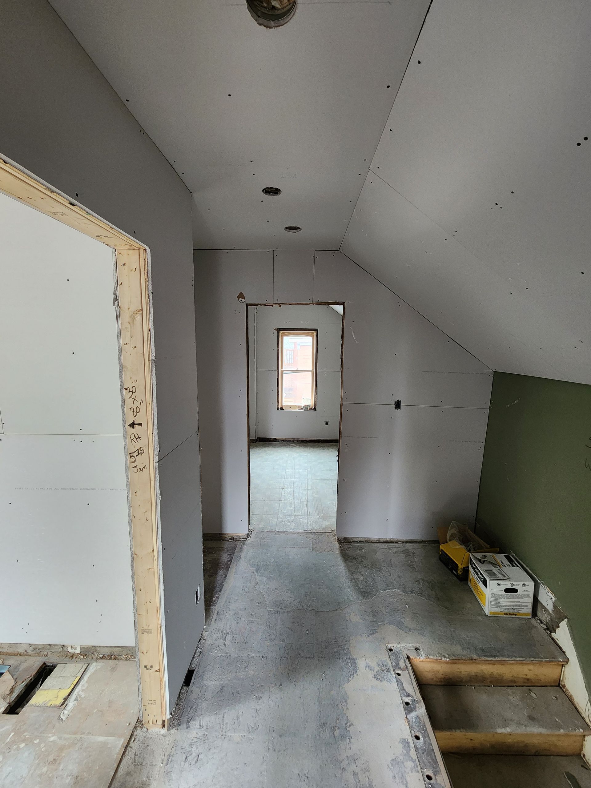 a hallway in a house under construction with a window .