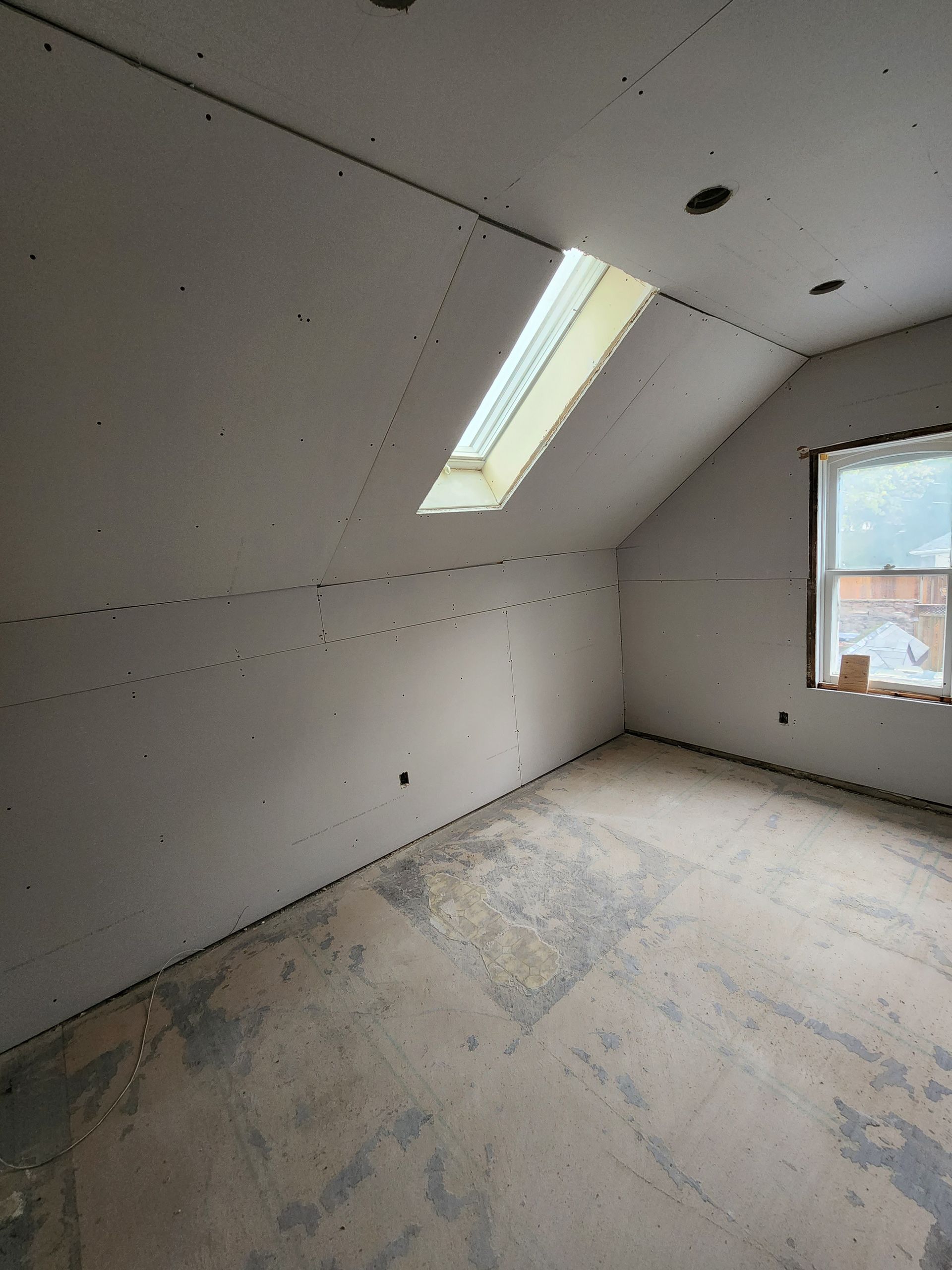 an empty room with a skylight in the ceiling