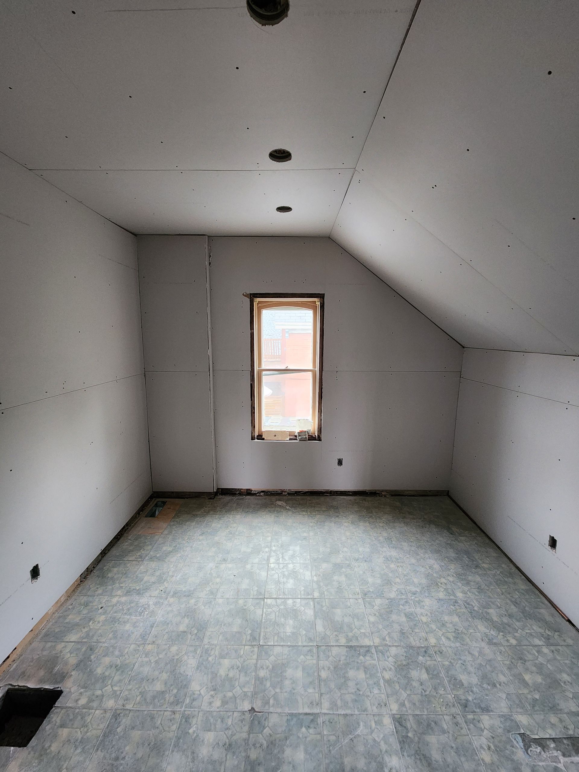 an empty room with a window in the corner