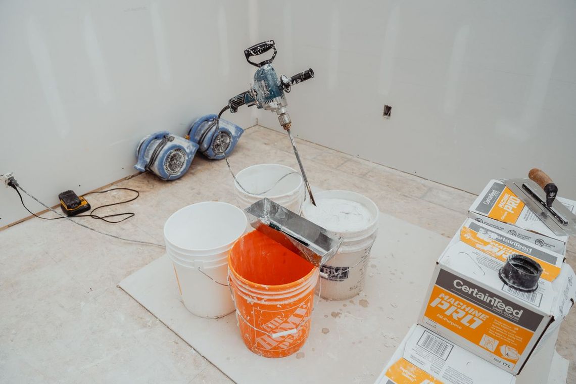 a man is plastering a ceiling with a trowel .