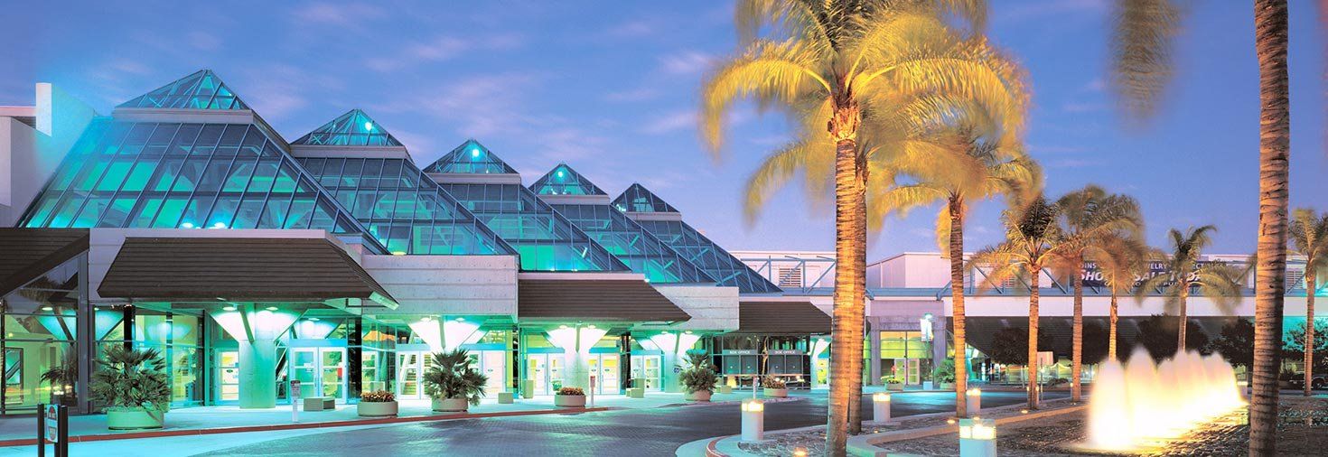 A large glass building with palm trees in front of it