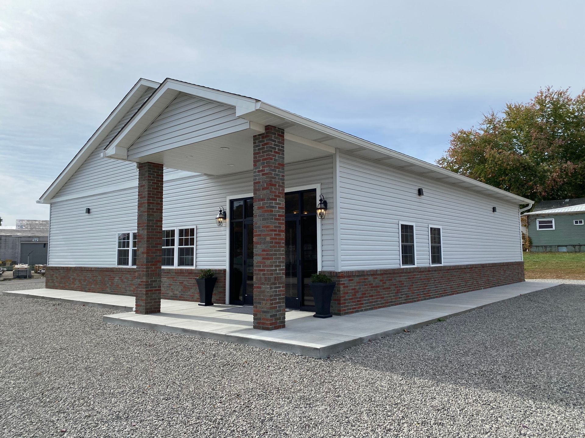 A large white building with a brown roof and a lot of windows.