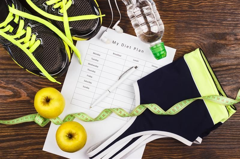 Weight loss therapy plan with apples, running shoes, water bottle, and fitness gear.