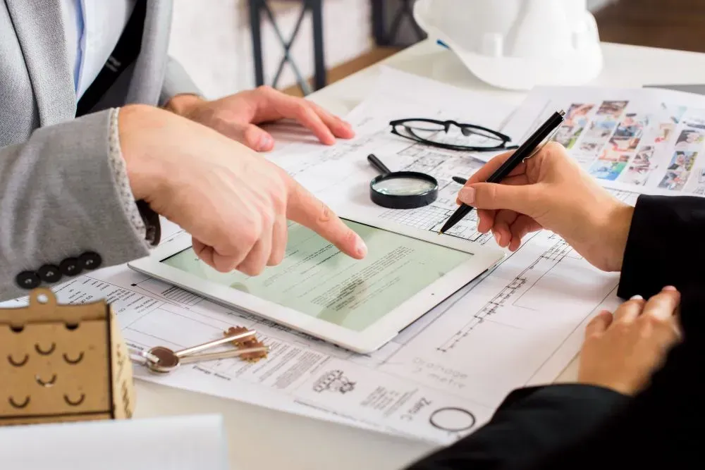 A doctor is sitting at a table talking to two elderly people.