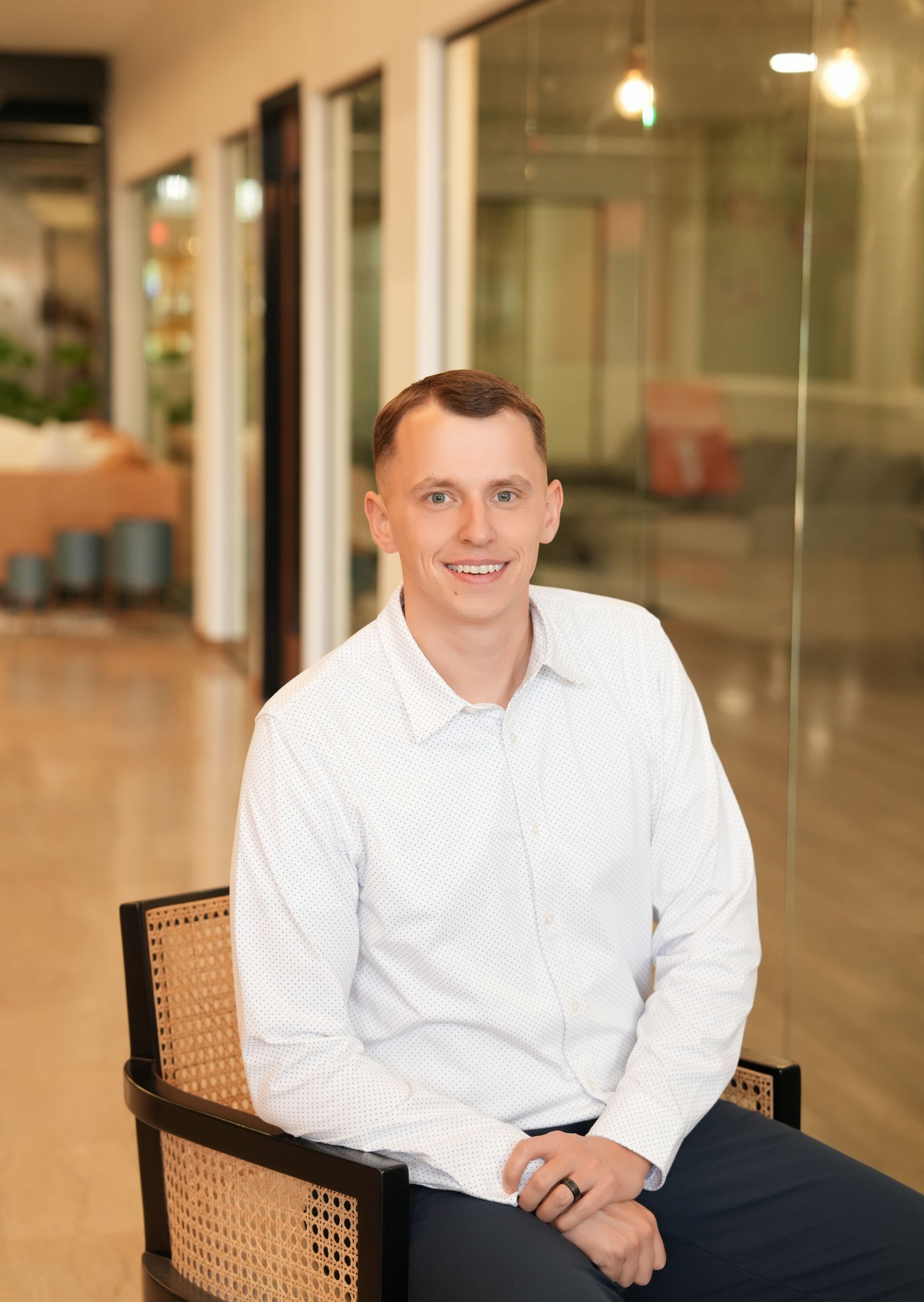 A man in a white shirt is sitting in a chair.