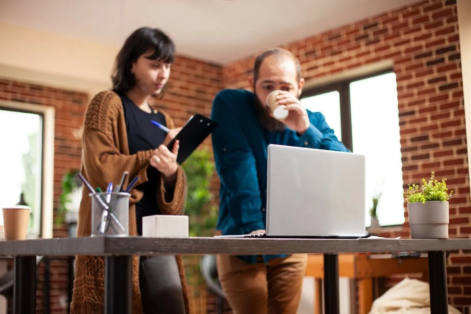 A doctor is sitting at a table talking to two elderly people.
