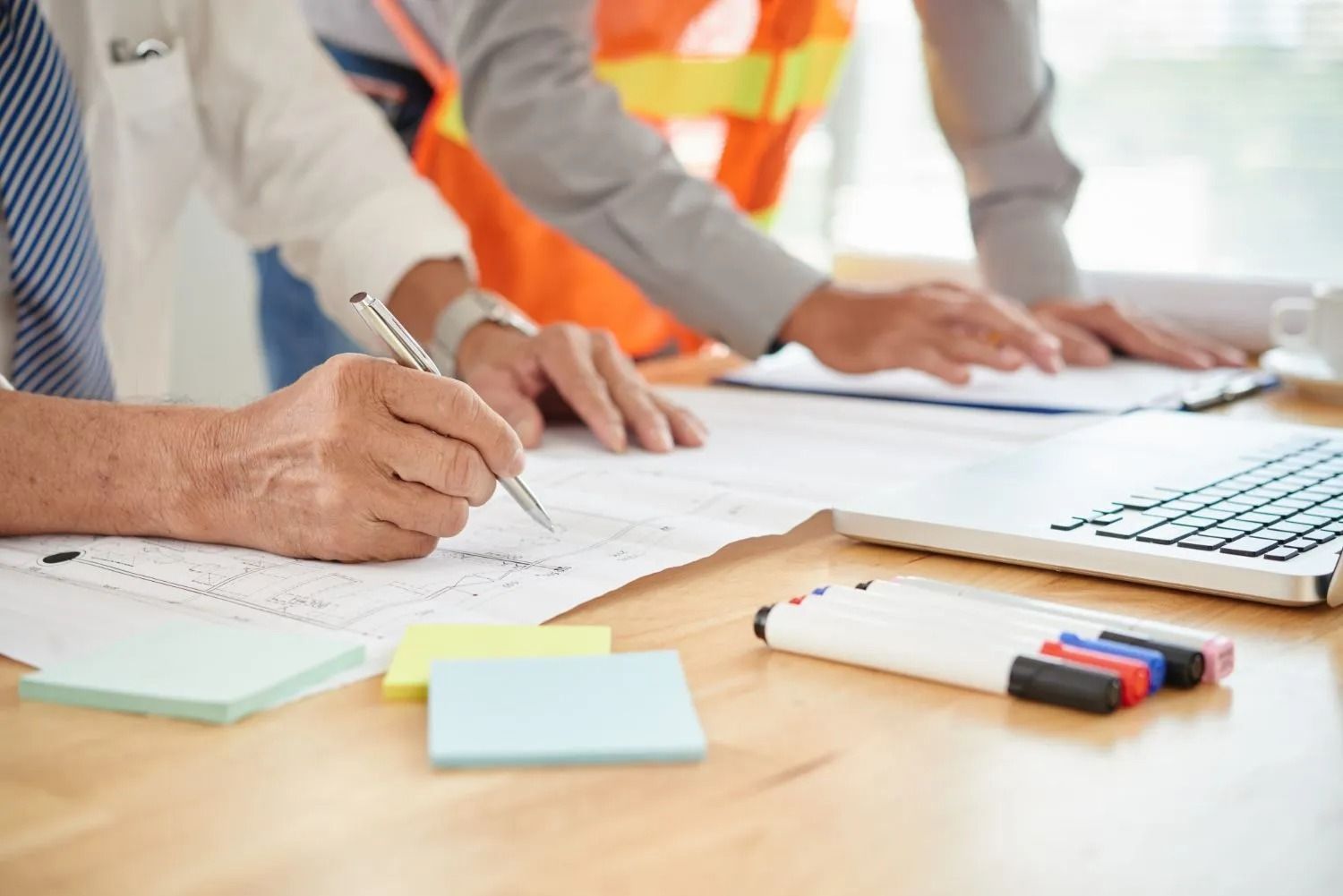 A doctor is sitting at a table talking to two elderly people.