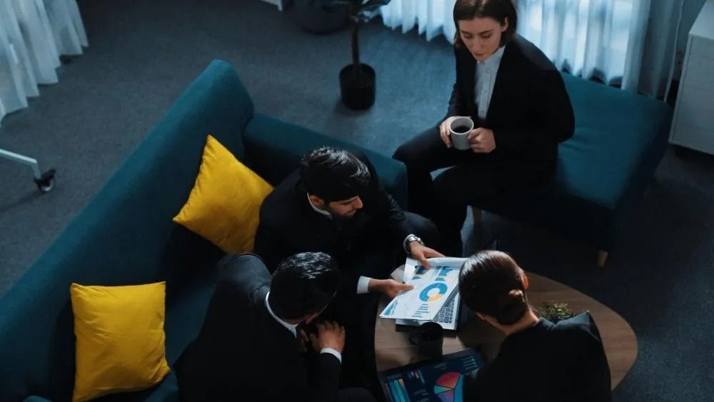 A doctor is sitting at a table talking to two elderly people.