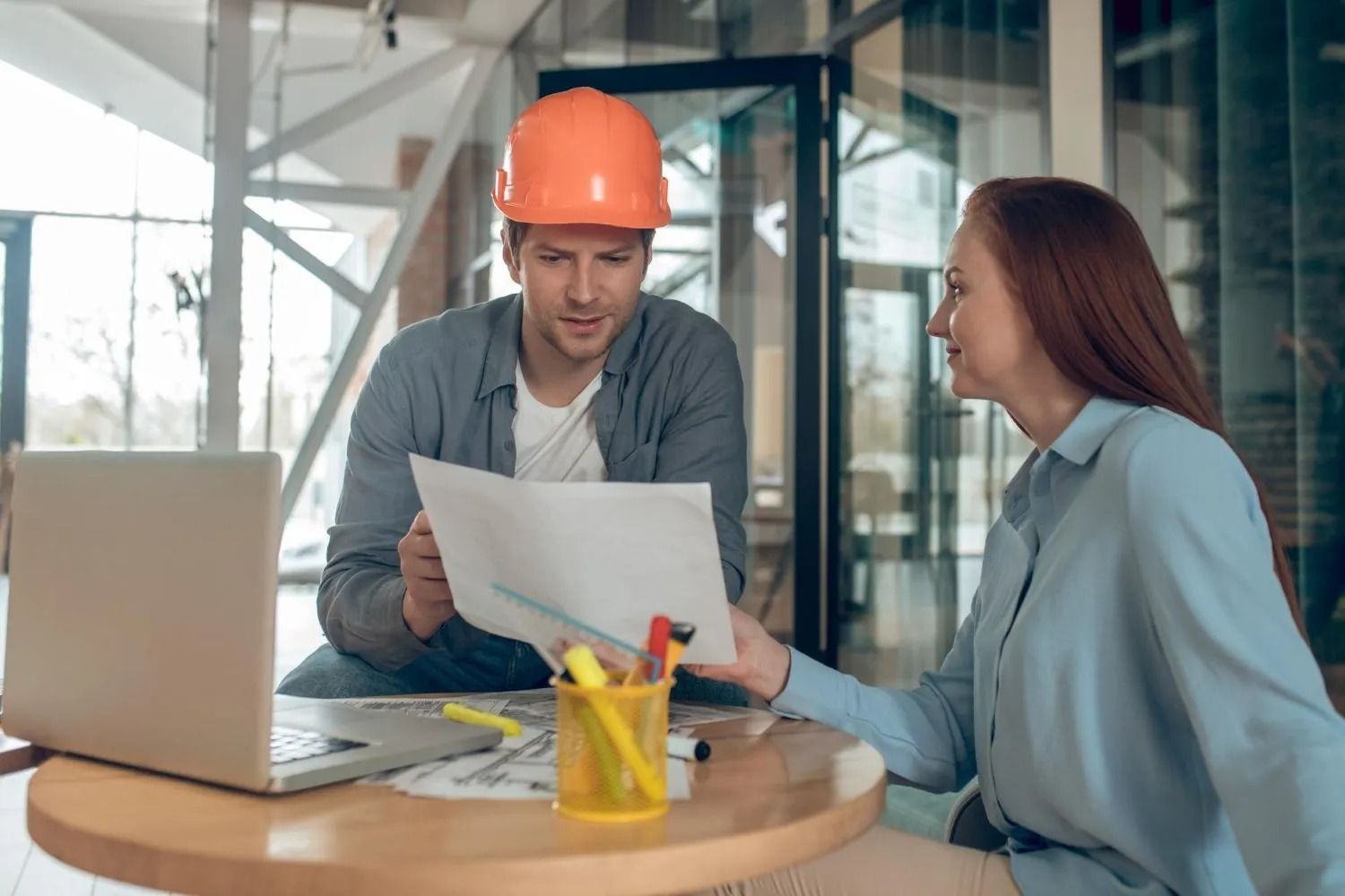 A doctor is sitting at a table talking to two elderly people.