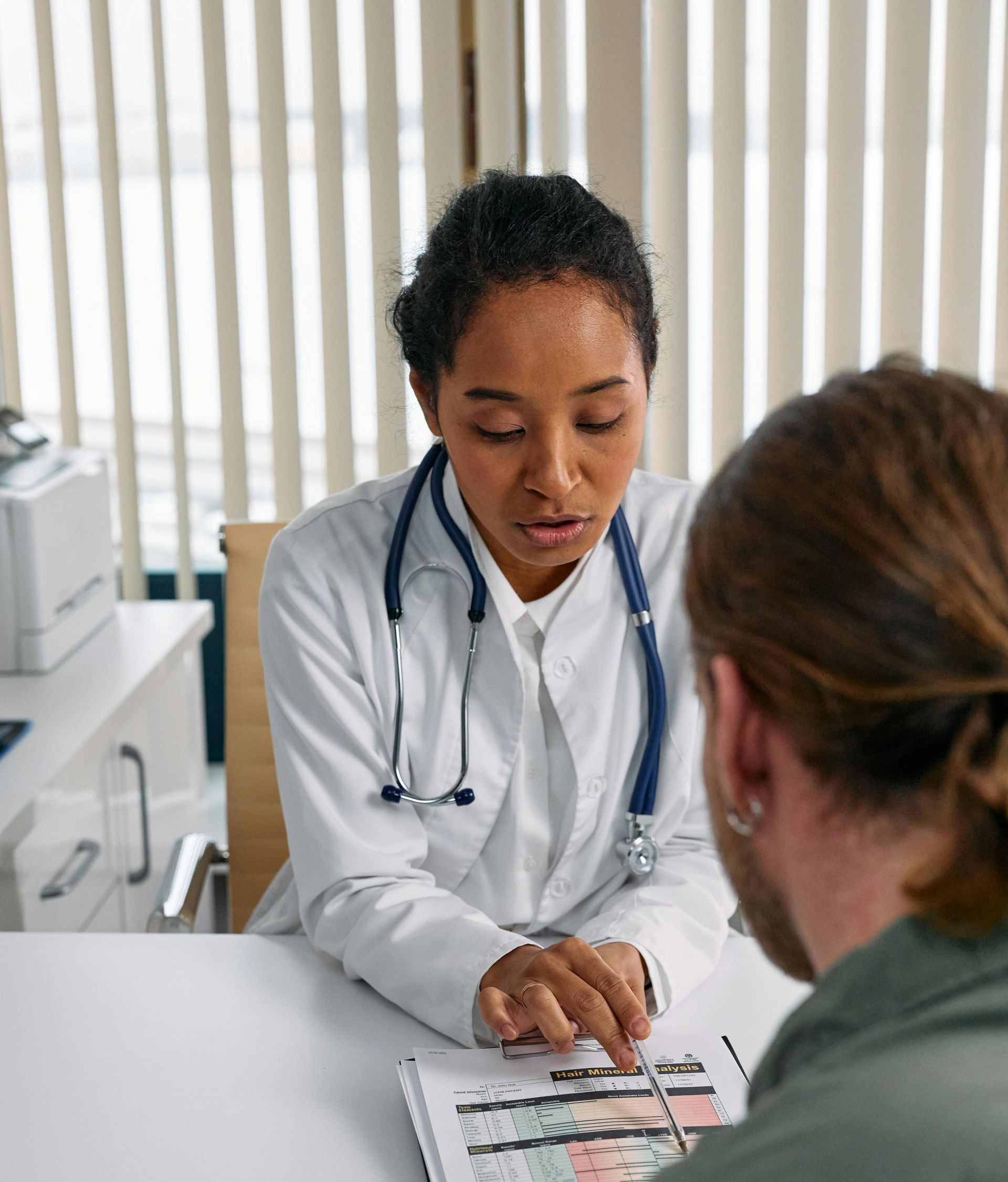 A man and a woman are sitting at a desk looking at a computer screen.
