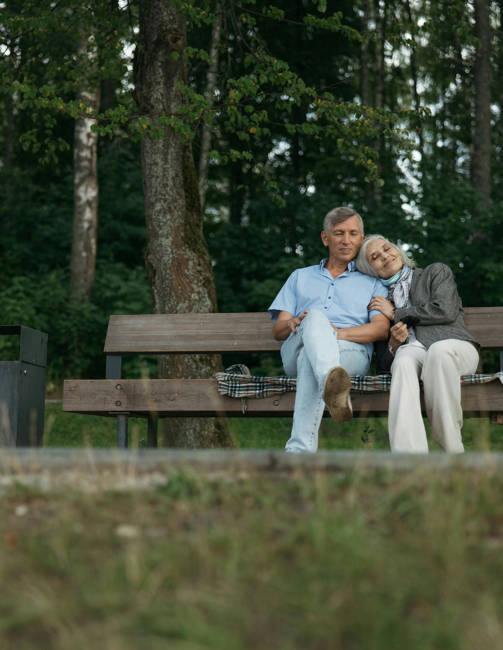A man and a woman are sitting at a desk looking at a computer screen.