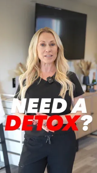 A woman in a black shirt is standing in a living room.