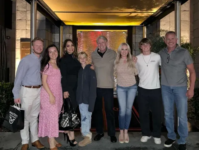A group of people posing for a picture in front of a building.