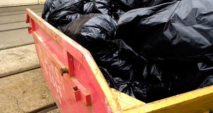 skip filled with black bags