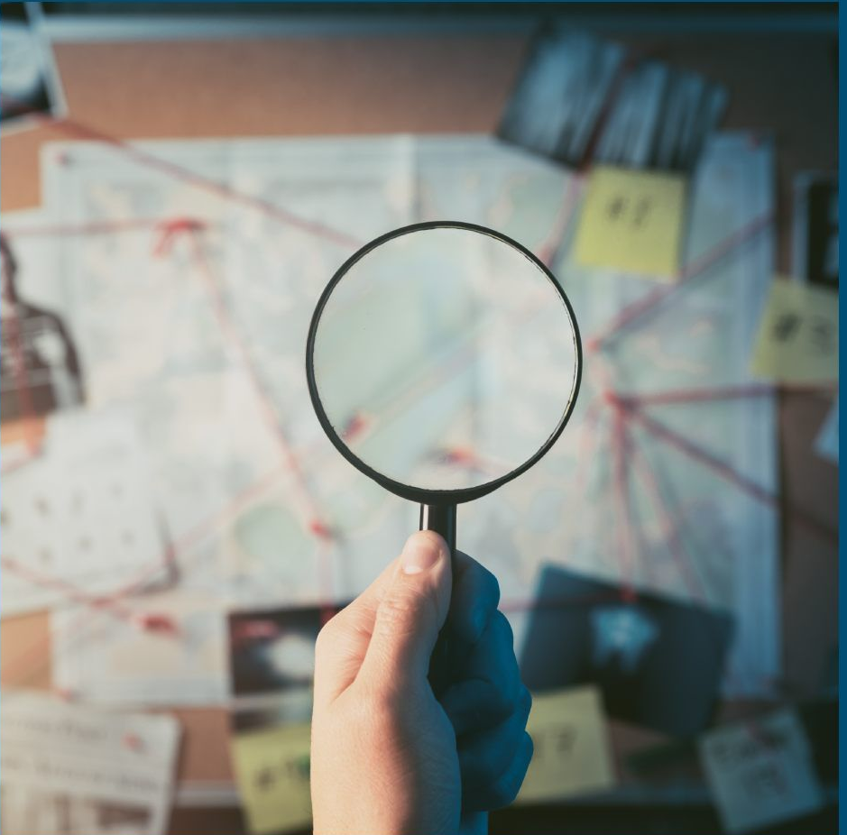 A hand holding a magnifying glass over a cluttered investigation board with red string, photos, and sticky notes.